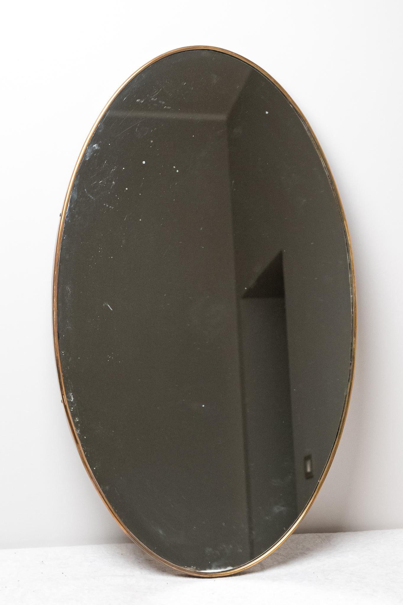 Specchio ovale in ottone, Made in Italy, Anni '50. 
Elegante Specchio da parete in ottone massiccio prodotto in Italia negli Anni '50. 
E' tutto ORIGINALE, sia specchio che cornice e mantiene la patina del tempo. 
Può presentare lievi segni di usura