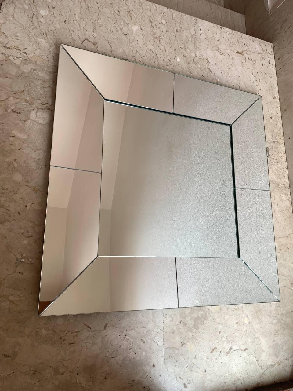 Questo imponente specchio da parete, databile intorno al 2006, incarna perfettamente l'estetica del design dei primi anni 2000, unendo funzionalità e un tocco di raffinatezza contemporanea. Le sue dimensioni generose, 80x80 cm, lo rendono un