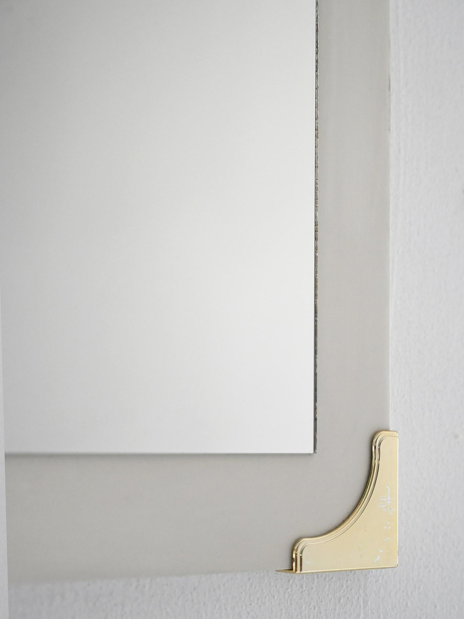 Espejo vintage con borde de madera lacada en blanco y esquinas decorativas de latón dorado.

Espejo de pared de origen escandinavo, fabricado entre los años 40 y 50. El marco de madera está acabado con barniz blanco mate, enriquecido con cuatro