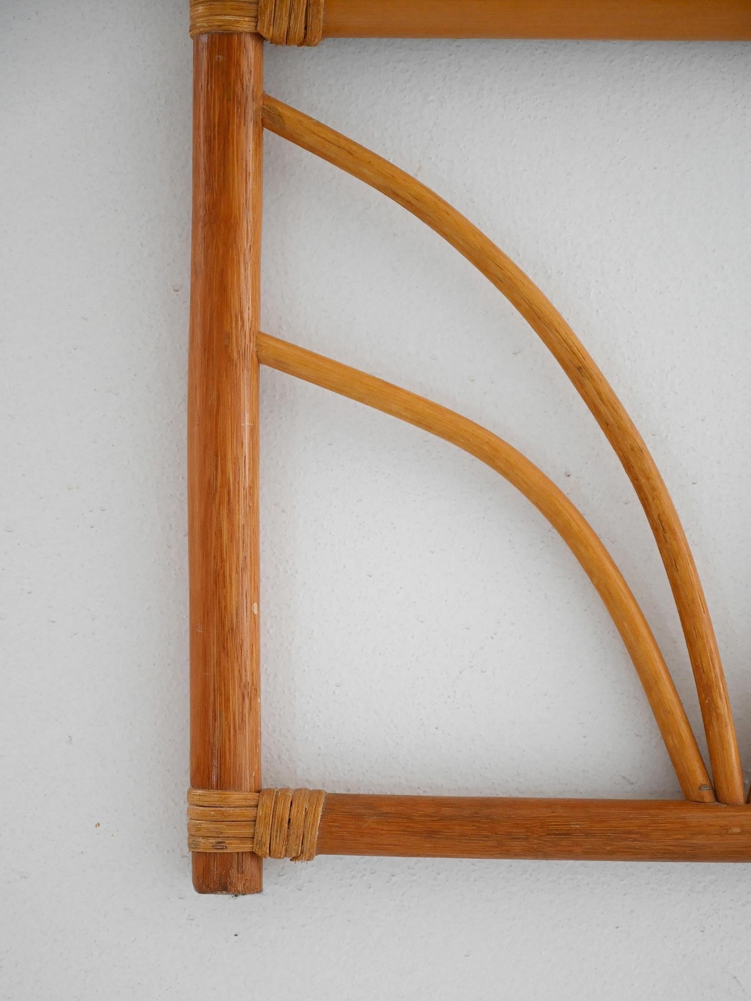 Cornice in bambù curvato con profilo nero interno. Forma verticale ad arco e dettagli decorativi intrecciati.

Specchio da parete scandinavo vintage realizzato negli anni ’70 con struttura in bambù curvato e cornice interna in legno nero. Il profilo