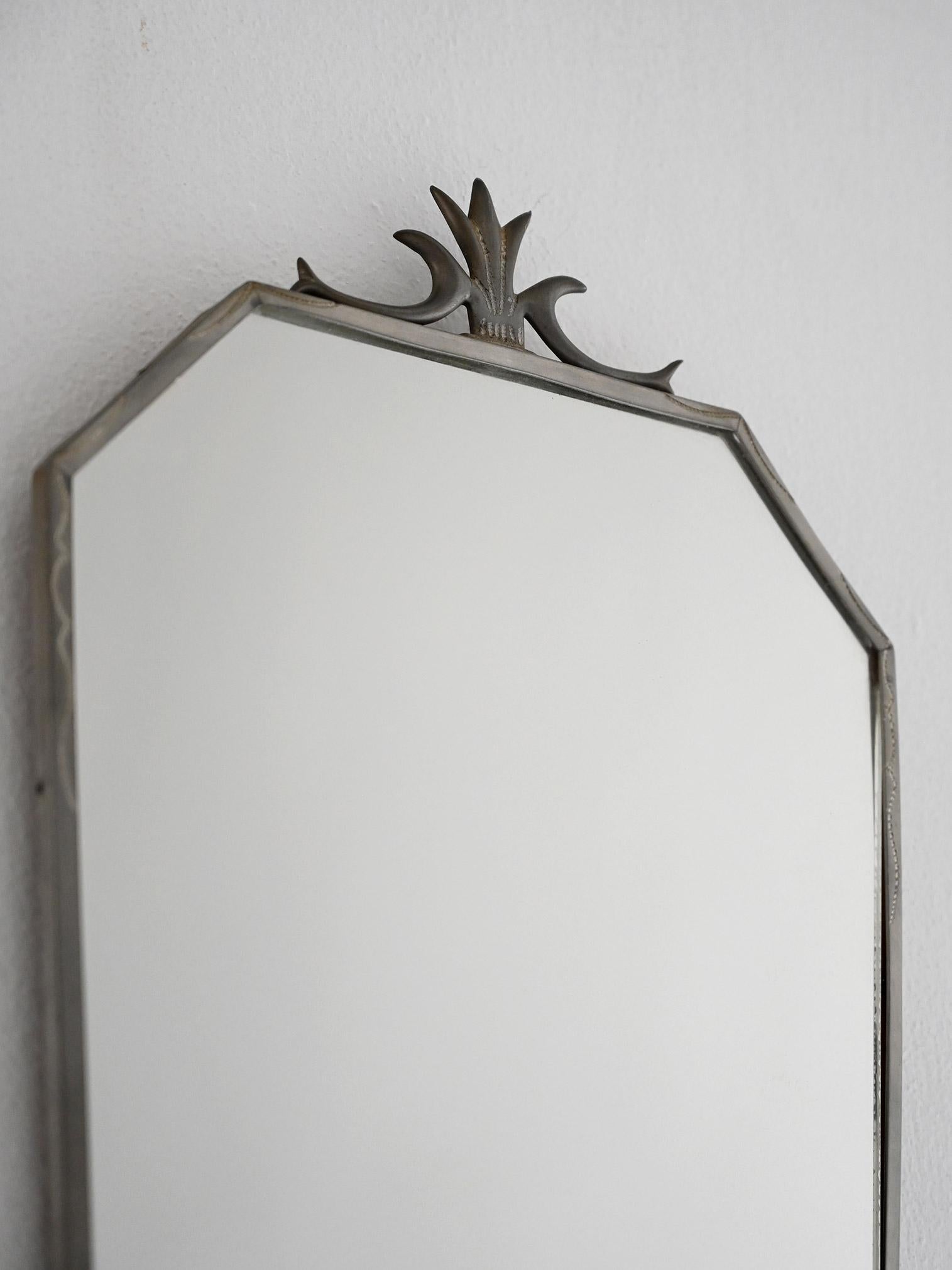 Espejo vintage con marco de hojalata trapezoidal, decoración floral y cristal original con imperfecciones.

Espejo de pared de fabricación escandinava, fechado en 1931, con marco de hojalata hecho a mano. El perfil trapezoidal está adornado con