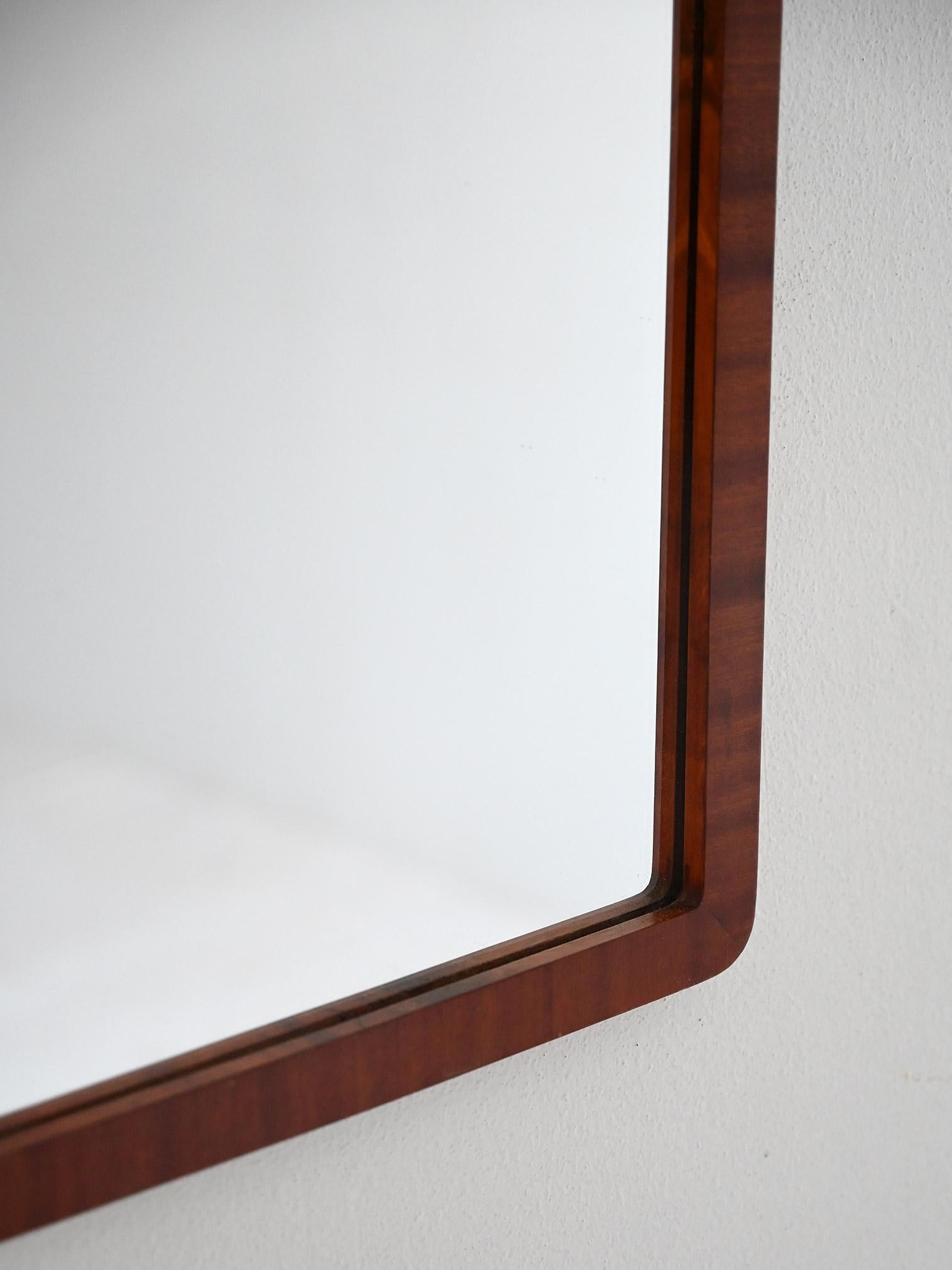 Espejo vertical con marco de caoba lacada y perfil redondeado, producción escandinava años 40.

Espejo de pared de la época decó, fabricado en Escandinavia en la década de 1940. Armazón de madera de caoba con acabado lacado brillante y perfiles