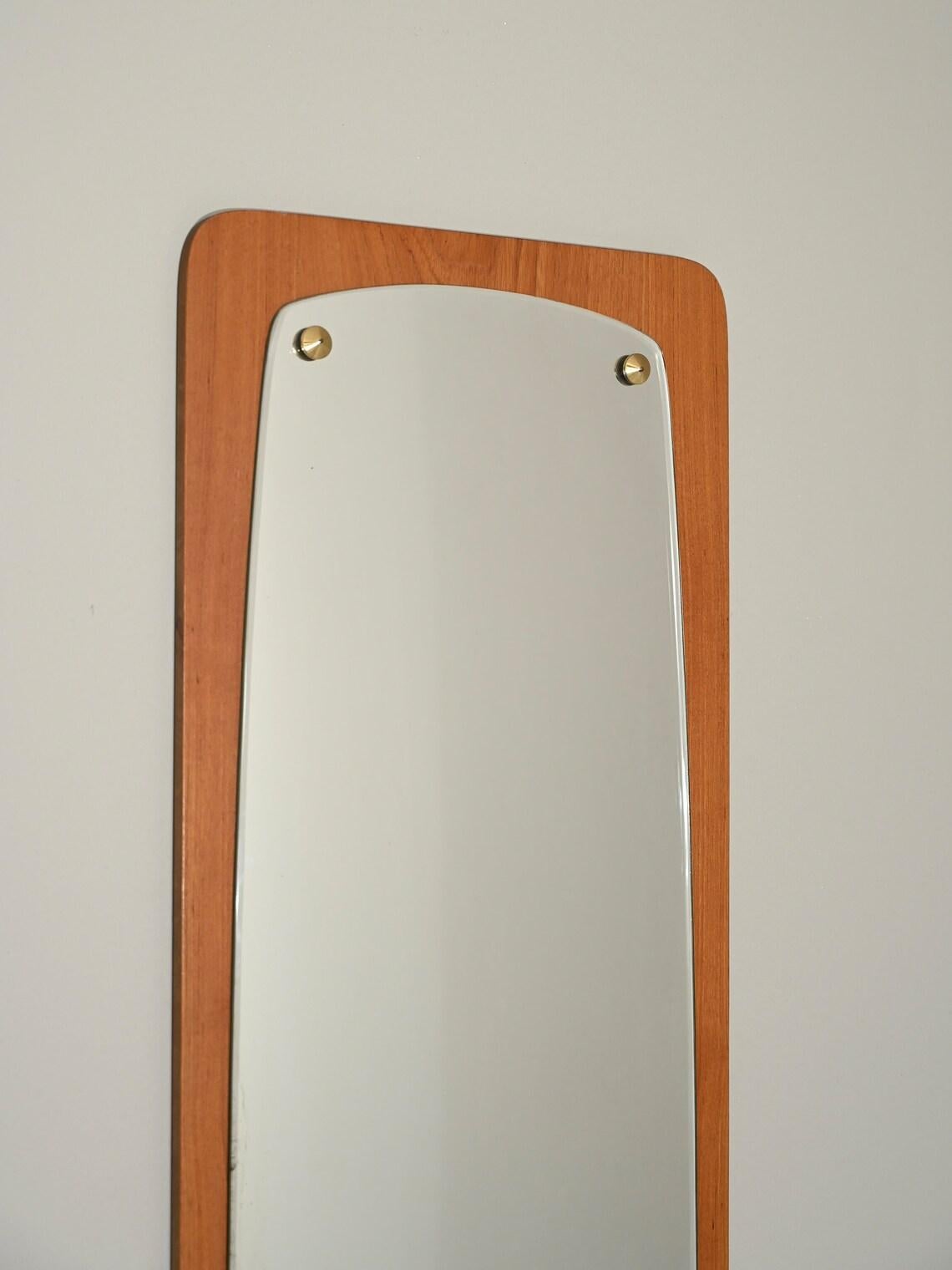 Miroir mural allongé avec cadre en bois de teck.

Bon état vintage. Le verre est partiellement oxydé. 

BC002