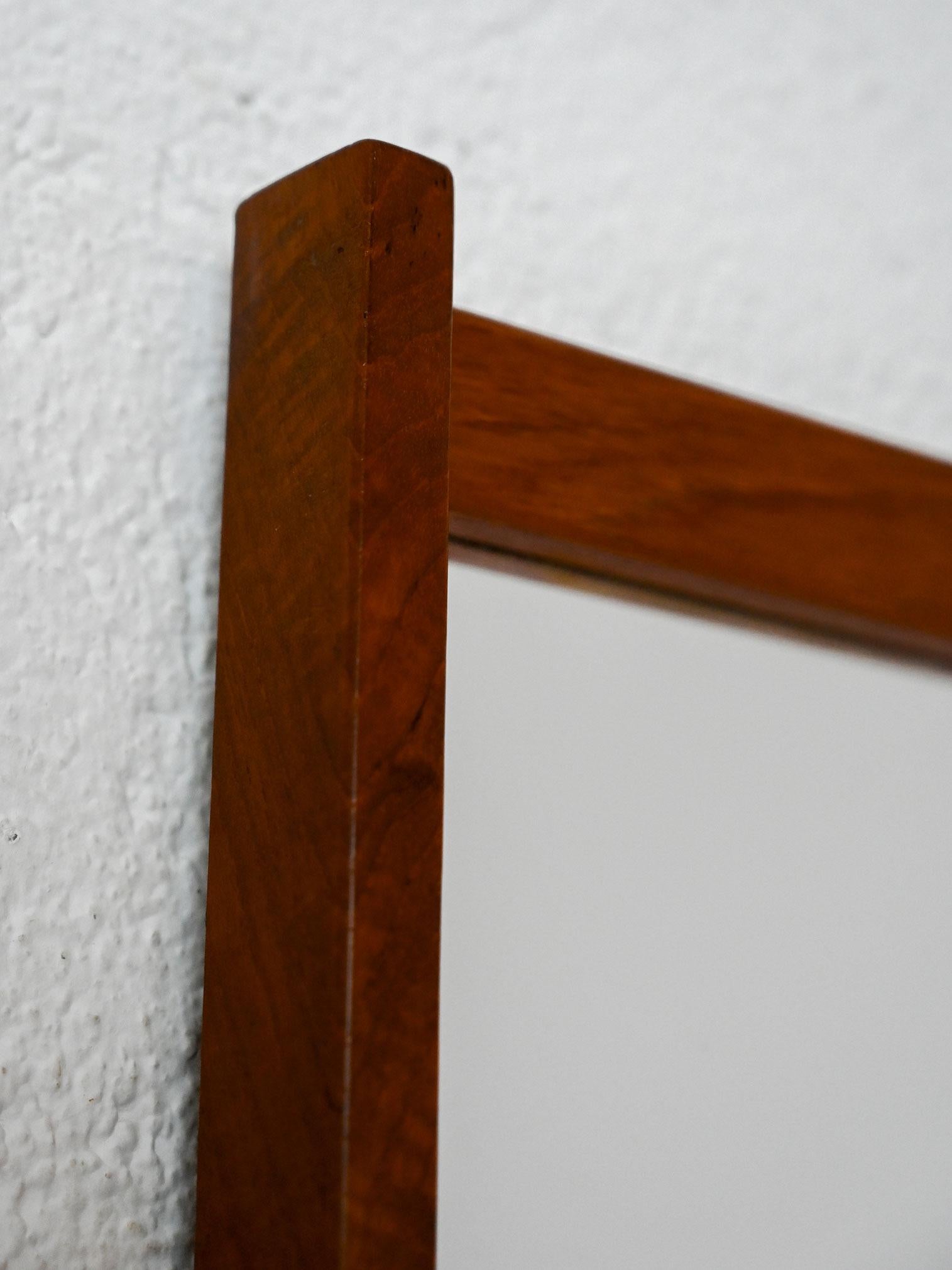 Miroir rectangulaire des années 1960 avec cadre en teck. Un design scandinave essentiel, caractérisé par des lignes épurées et une finition chaleureuse.

Miroir vintage des années 1960 avec cadre en teck, typique du design scandinave pour sa