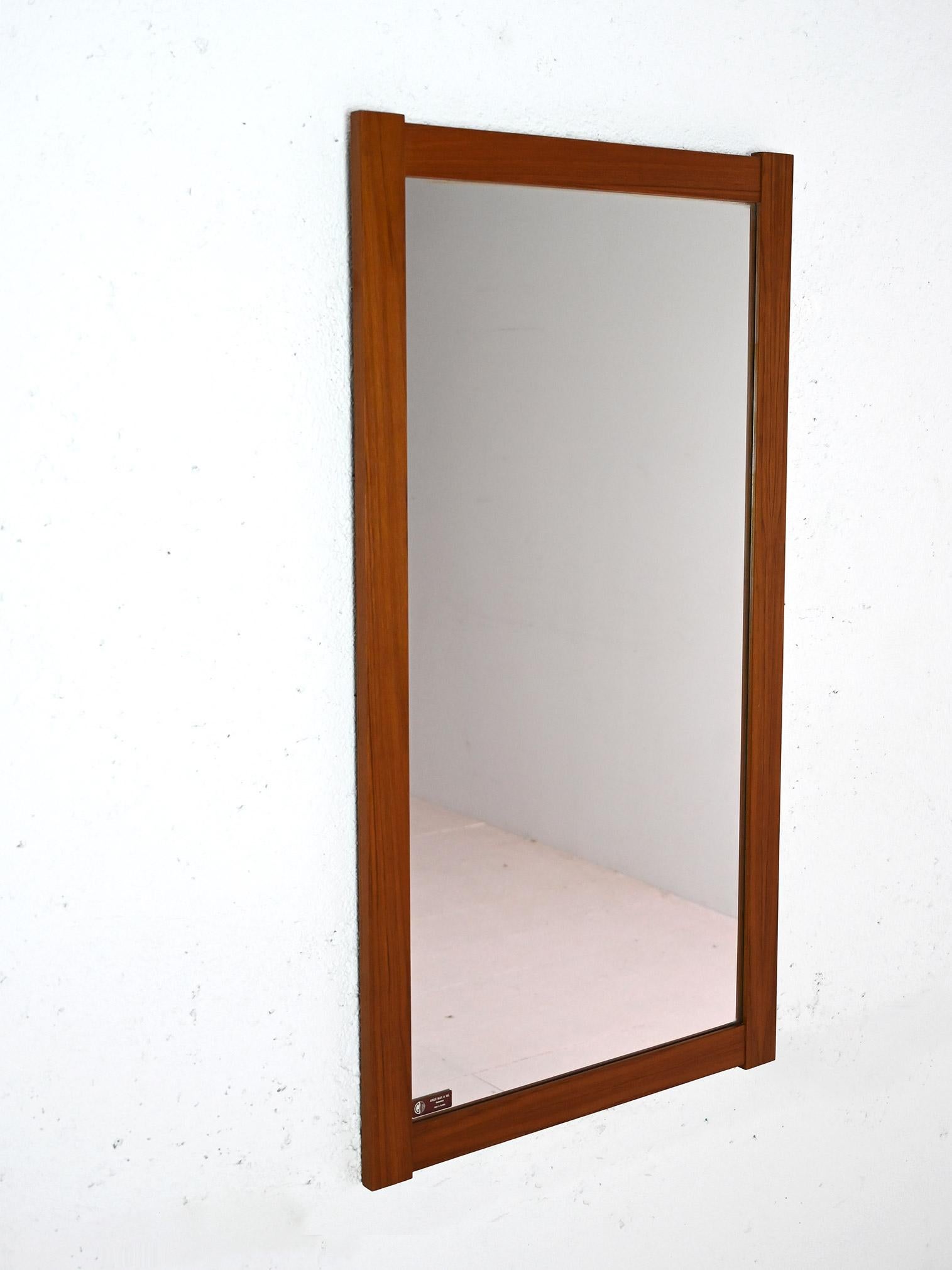 Miroir rectangulaire avec cadre en teck massif dont les longs côtés dépassent légèrement. 

Caractérisé par des lignes carrées et minimalistes, il s'adapte aux contextes modernes et à différents types d'environnements. 
Bon état. Il peut présenter