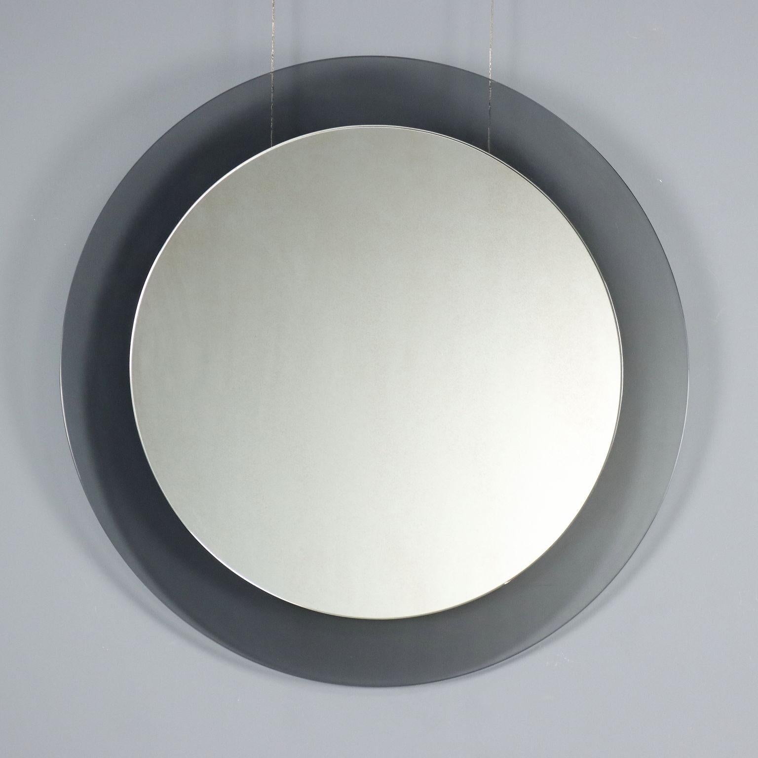 Wall mirror of circular shape with glass frame in smoky moles; production mark present on the back.