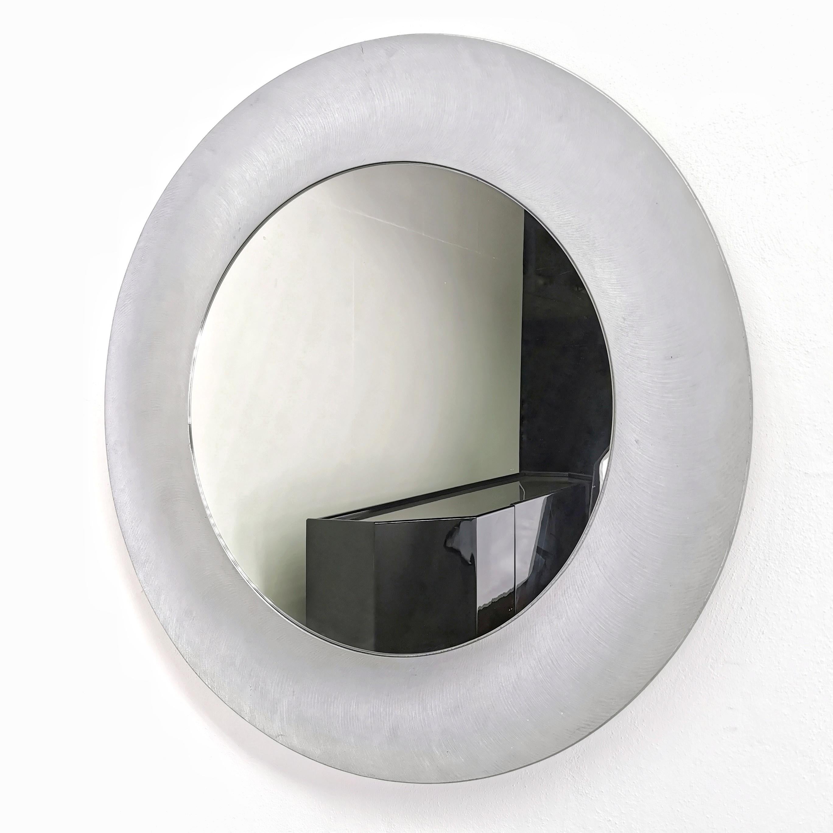 Rare round sculptural mirror with modernist style  brutalist designed in the 1970s by 'artist sculptor Lorenzo Burchiellaro. 
the mirror features a textured aluminum casting with a slightly concave shape. 
The mirror is in perfect condition with no