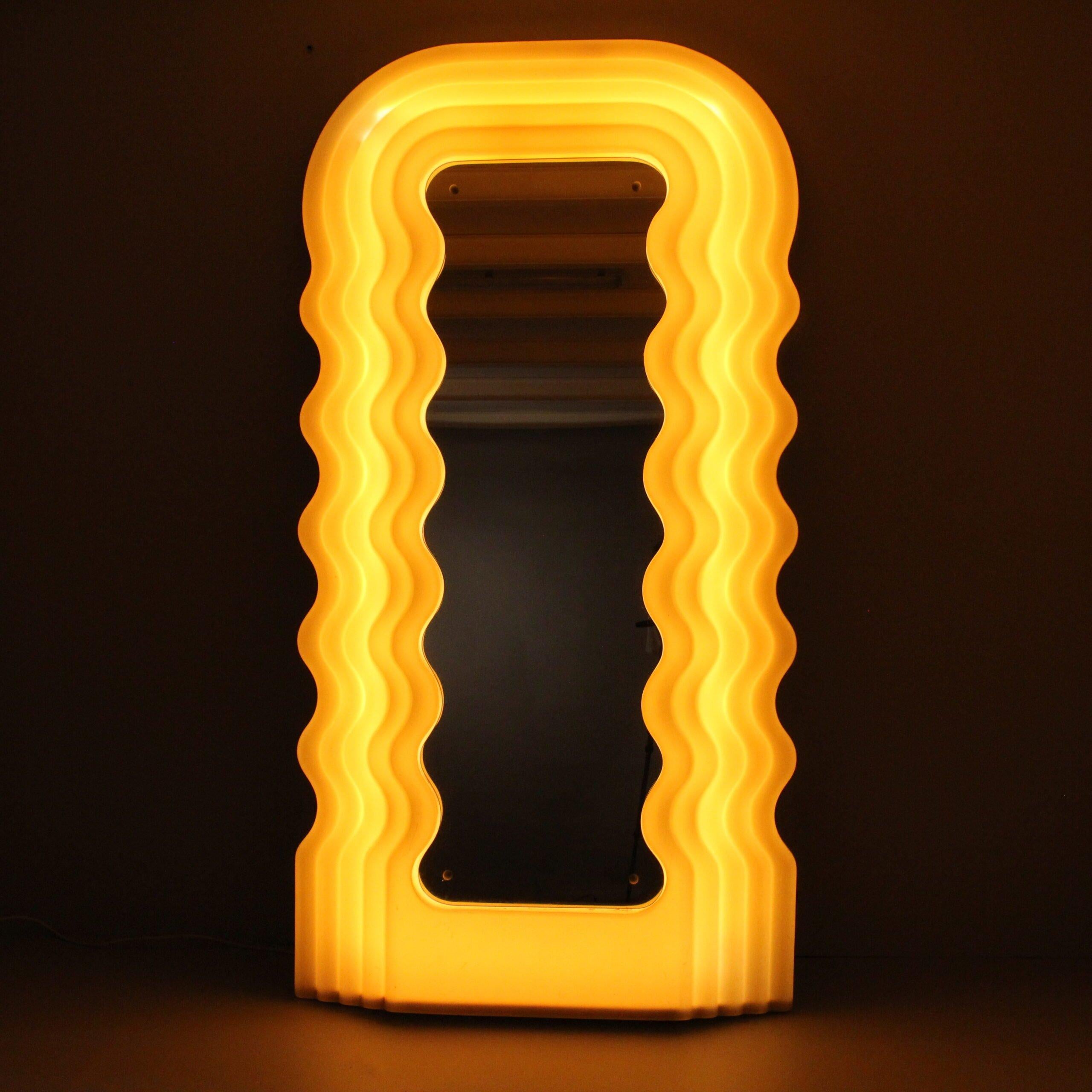 Le miroir lumineux Ultrafragola a été conçu par Ettore Sottsass, avec sa silhouette sinueuse évoquant une chevelure féminine ondulée. Il appartient à la série des Mobili Grigi, une chambre à coucher et un salon complets conçus par Ettore Sottsass