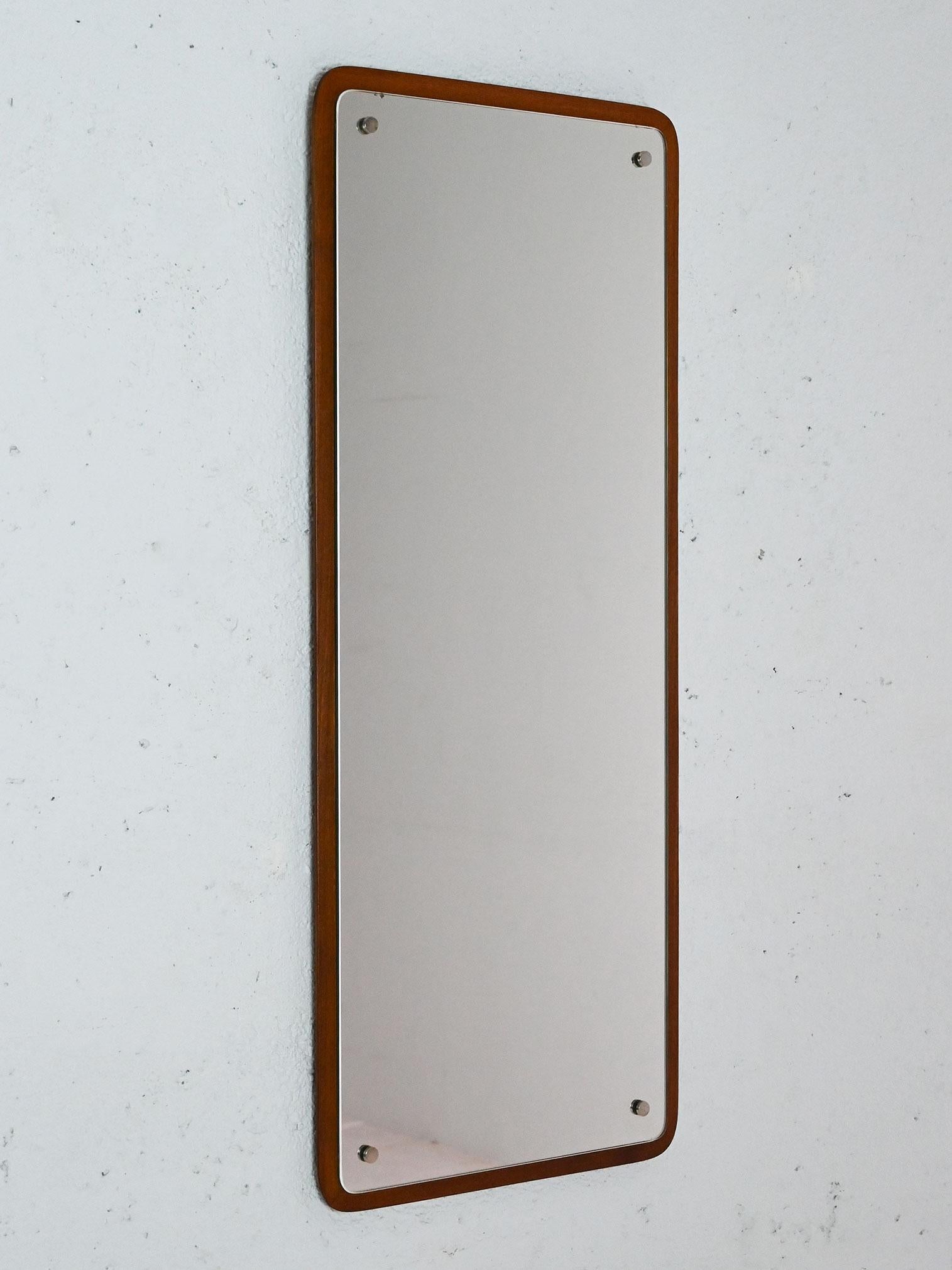 Miroir rectangulaire scandinave avec coins arrondis et détails en laiton. 

La forme régulière du cadre en bois se distingue par les lignes douces des coins et la présence des quatre boulons métalliques qui renforcent la tenue.  Bon état. Il peut