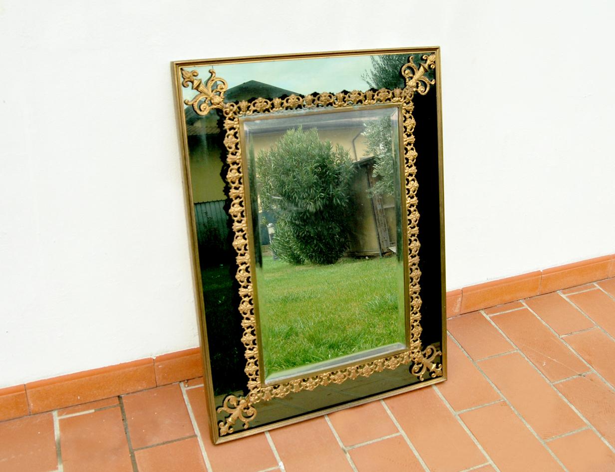 Magnifique miroir vintage avec d'élégantes décorations en laiton.
L'objet comporte un miroir périphérique de couleur verte avec un cadre en laiton, un miroir central monté en relief, également avec un cadre en laiton finement travaillé. Le tout est