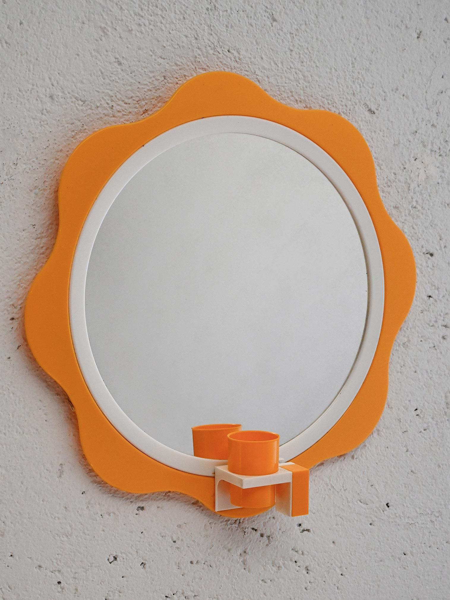 Espejo finlandés vintage Mäkisen Kuvastin MK-298 de los años 60 con borde ondulado naranja y blanco, estilo Pop Art, y portacepillos de dientes integrado.

Espejo finlandés de época Mäkisen Kuvastin modelo MK-298, fabricado en la década de 1960. El