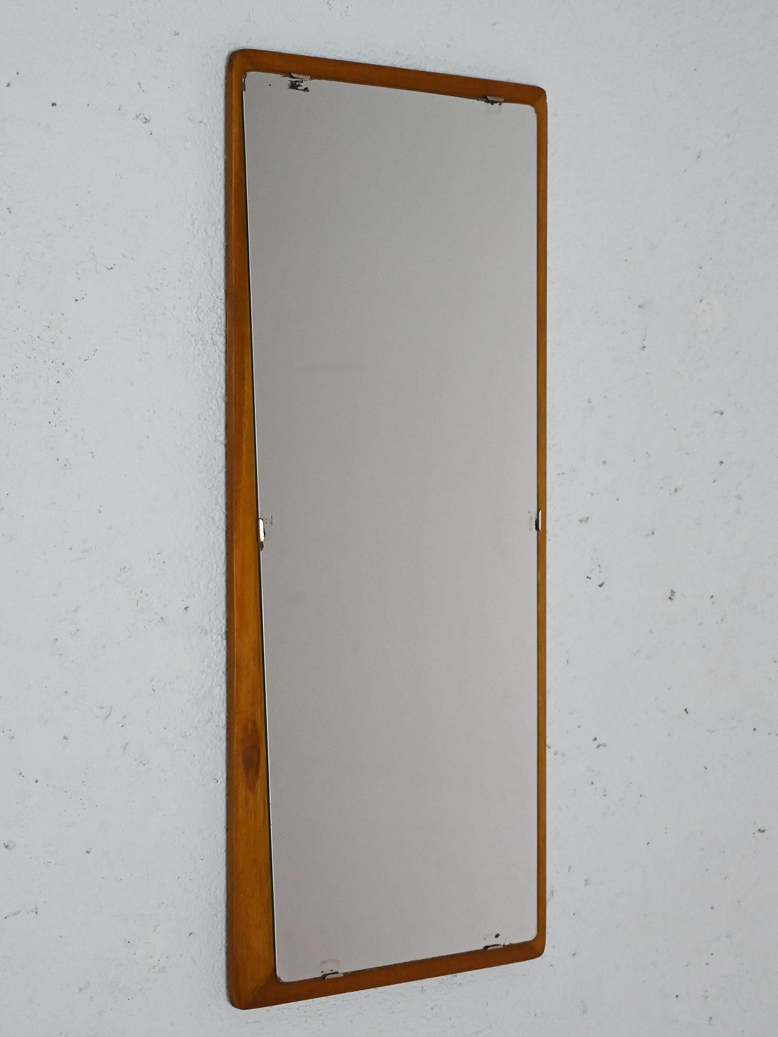 Espejo de los años 60 con marco rectangular de teca y espejo trapezoidal. 

Su estructura de teca y sus líneas minimalistas lo convierten en un mueble adecuado para diferentes estilos y estancias del hogar. Buen estado. Puede mostrar signos del paso