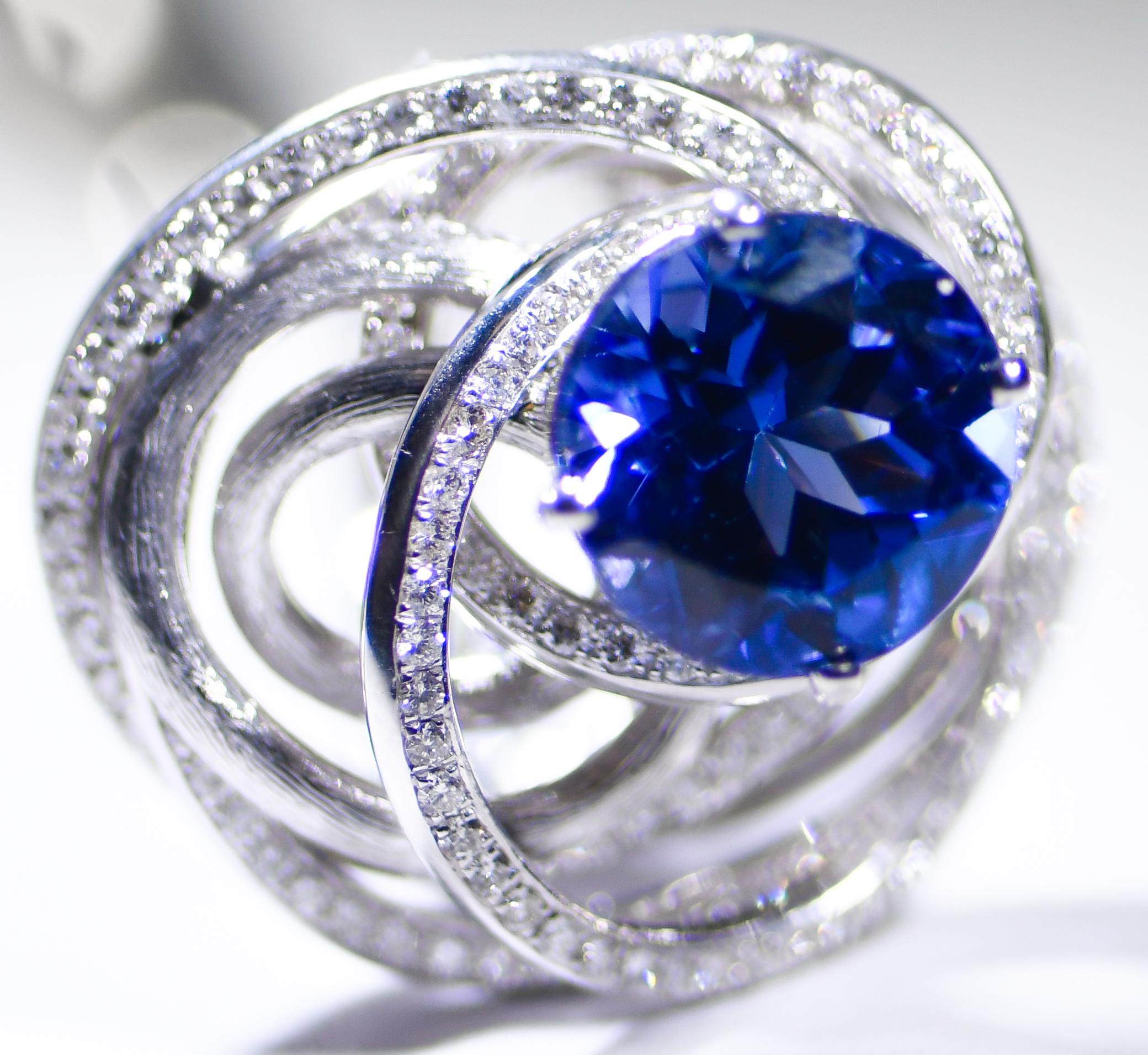 Supplies of Tanzanite with this depth and saturation of color are a RARE find!  A fully faceted round Tanzanite has an important weight of 7.98 carats.  Center stone is enhanced by open work swirls replete with white round diamonds with an