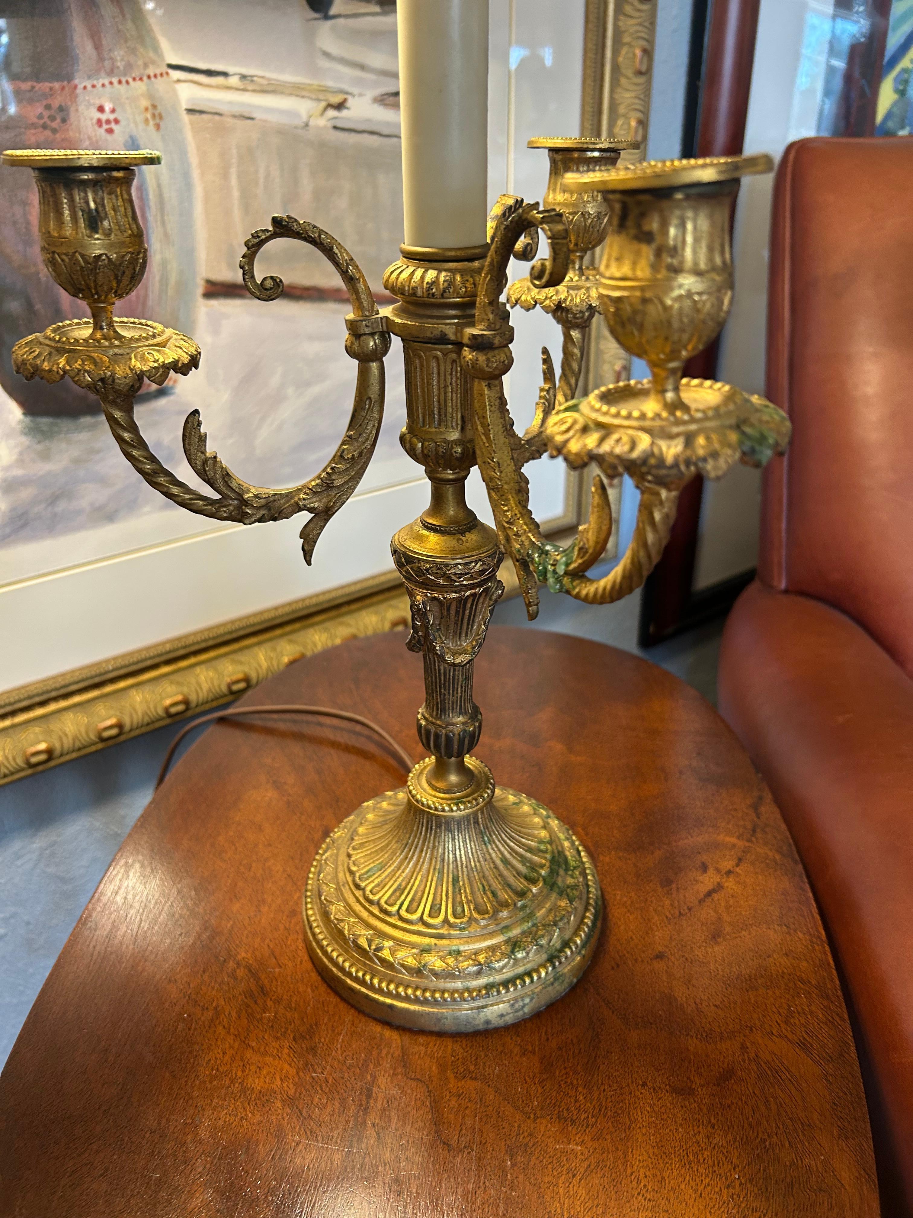 Lampada francese buillotte insolitamente particolare, con una base ornata a 3 candele contrastata e completata da un paralume in metallo grigio ardesia.  Il paralume è regolabile.  La ghiera è un tocco di classe.  Può ospitare due lampadine da 60