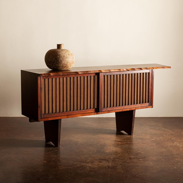 A truly exceptional example of George's work. This piece in lovely American black walnut and pandanus cloth. The tone of the wood in this example is darker than we typically see, which serves to highlight the grain and the movement along the live