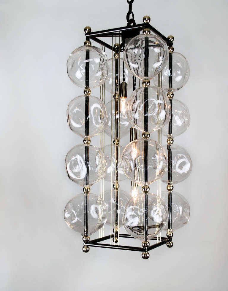 We have taken our opera chandelier and created this smaller scale chandelier. 16 hand blown glass, polished brass accents, gun metal patina frame.   Frame can be built either round or square.  Fixture has three candelabra based sockets. 60 Watts max