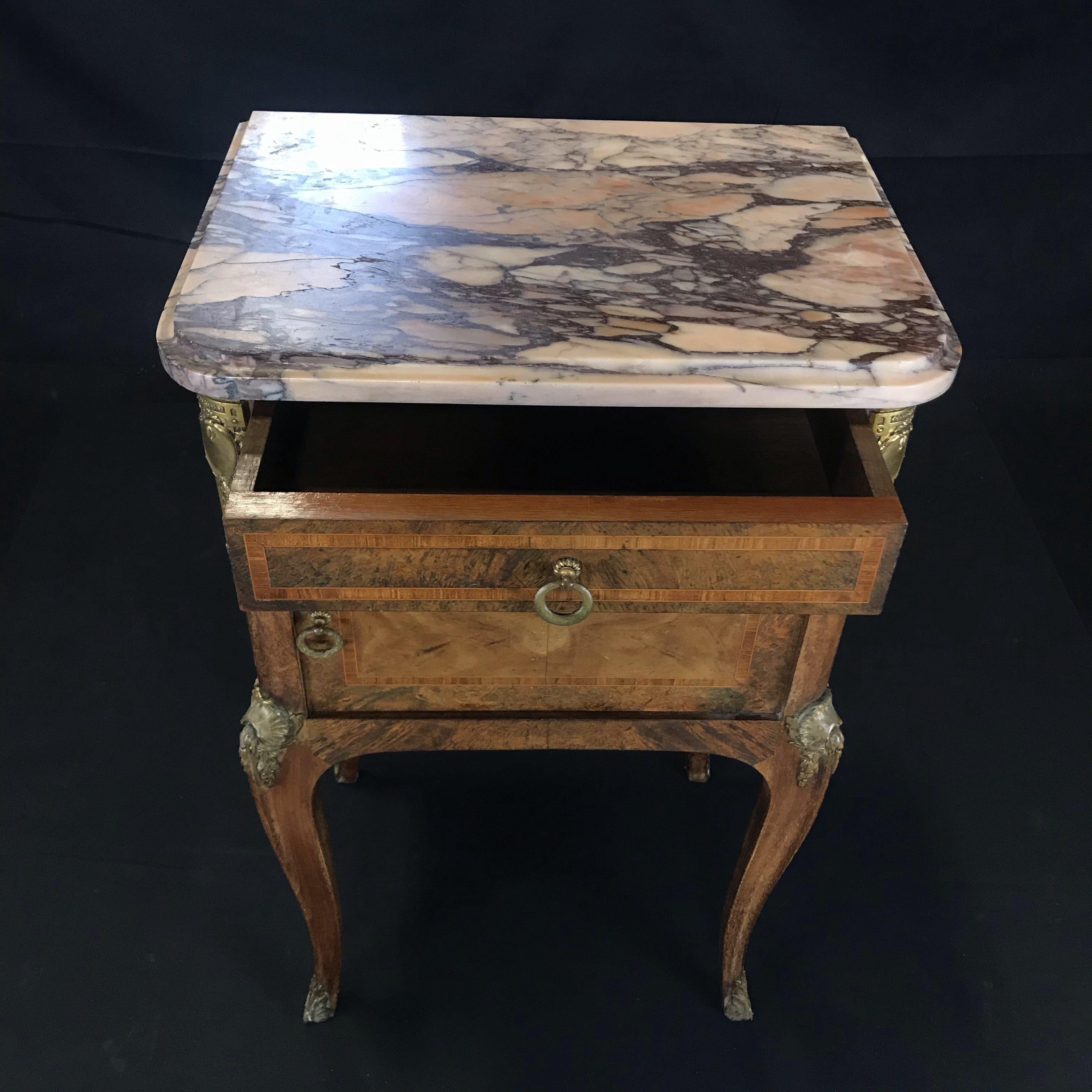 Special and lovely antique French walnut inlaid side cabinet or night stand having rouge and beige marble top and golden bronze adornments. Single drawer above cupboard. Very good antique condition for its age with only minor marks of use.

#3692.