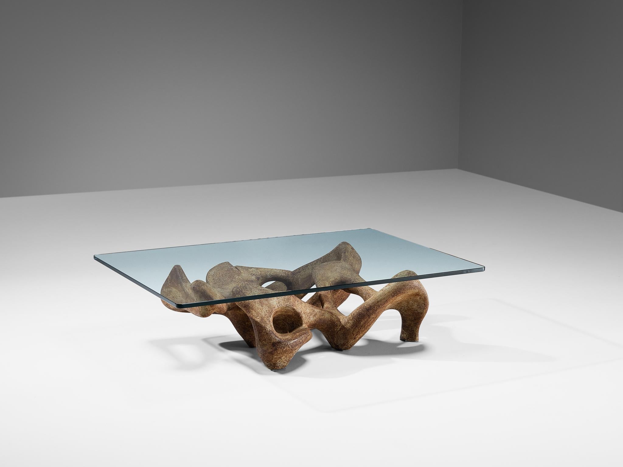 This sculptural table is attributed to the Italian designer Claudio Trevi. A sculptor by heart, which is clear to see in the design of this coffee table. The base is an organic and almost dreamlike modeled shape, executed in concrete. The