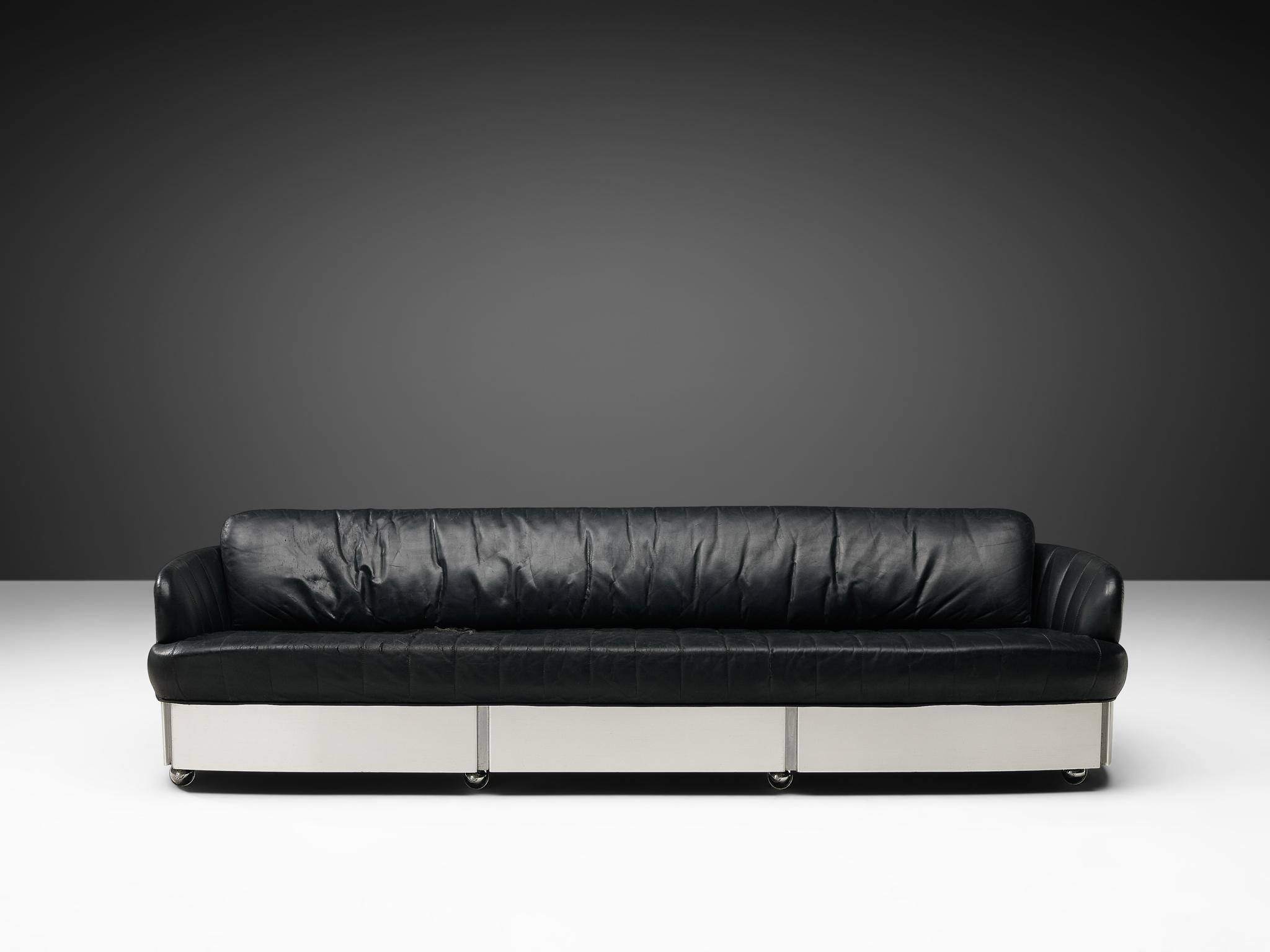 The large sofa features a brushed steel shell with thick, comfortable cushions inside. The black cushioning makes sure this sofa is highly comfortable. The brushed steel gives a slick finish to the couch. 

Please note that the item is in good, used