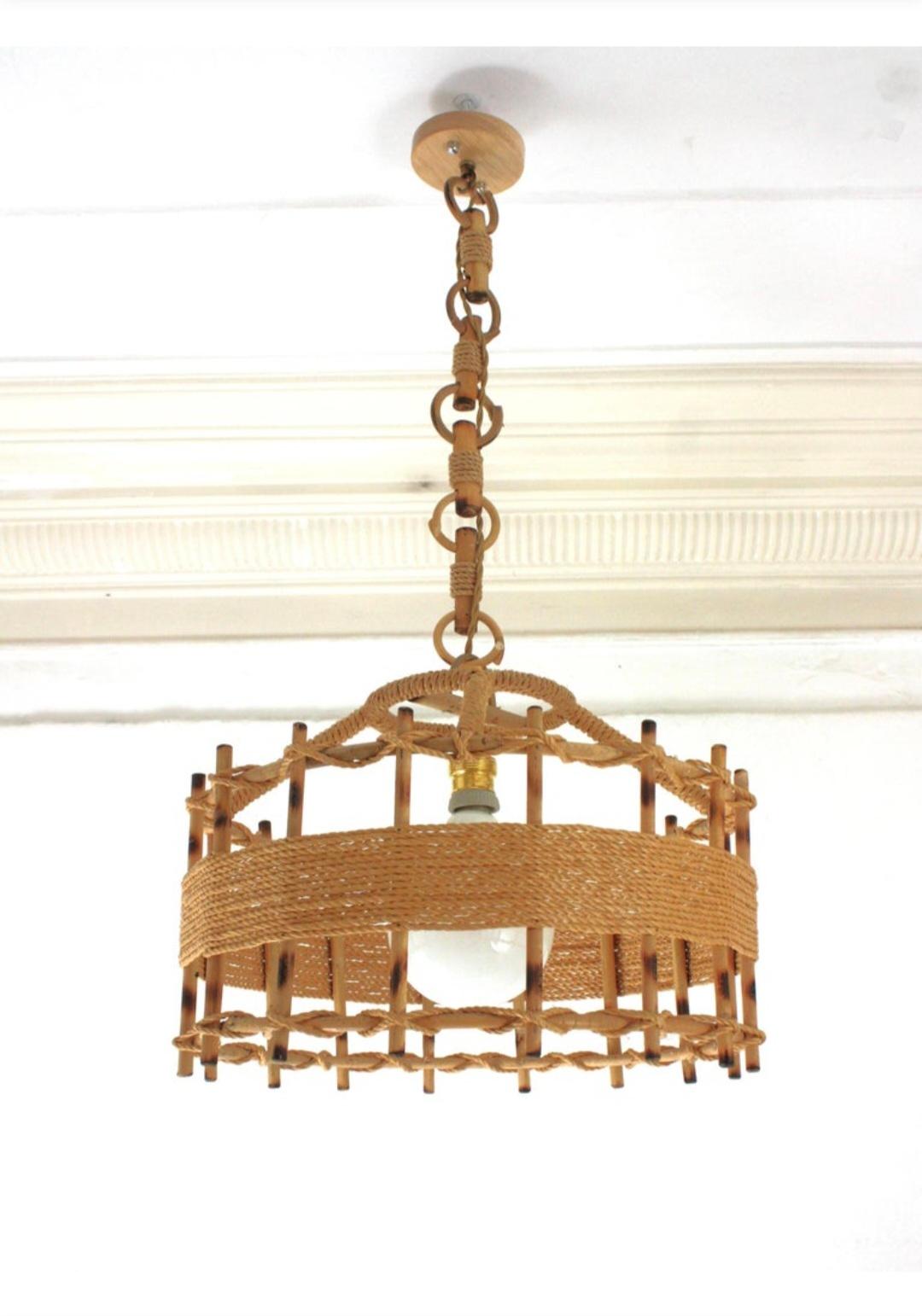 Lámpara de suspensión de techo artesanal en forma de tambor de cuerda y ratán. España, años 60
Este gran farol artesano tiene un llamativo diseño con una estructura cilíndrica hecha de palos de ratán envueltos y detallados con cuerda de yute.