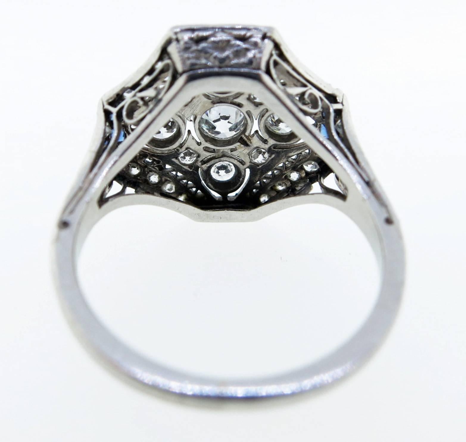 Platinum open work engraved mount ring circa 1925. The center is set with 5 bezel set round European cut diamonds totaling approx .55cts.  The handmade open lace work mount is is bead set with 20 old cut diamonds and  channel set with 12 natural