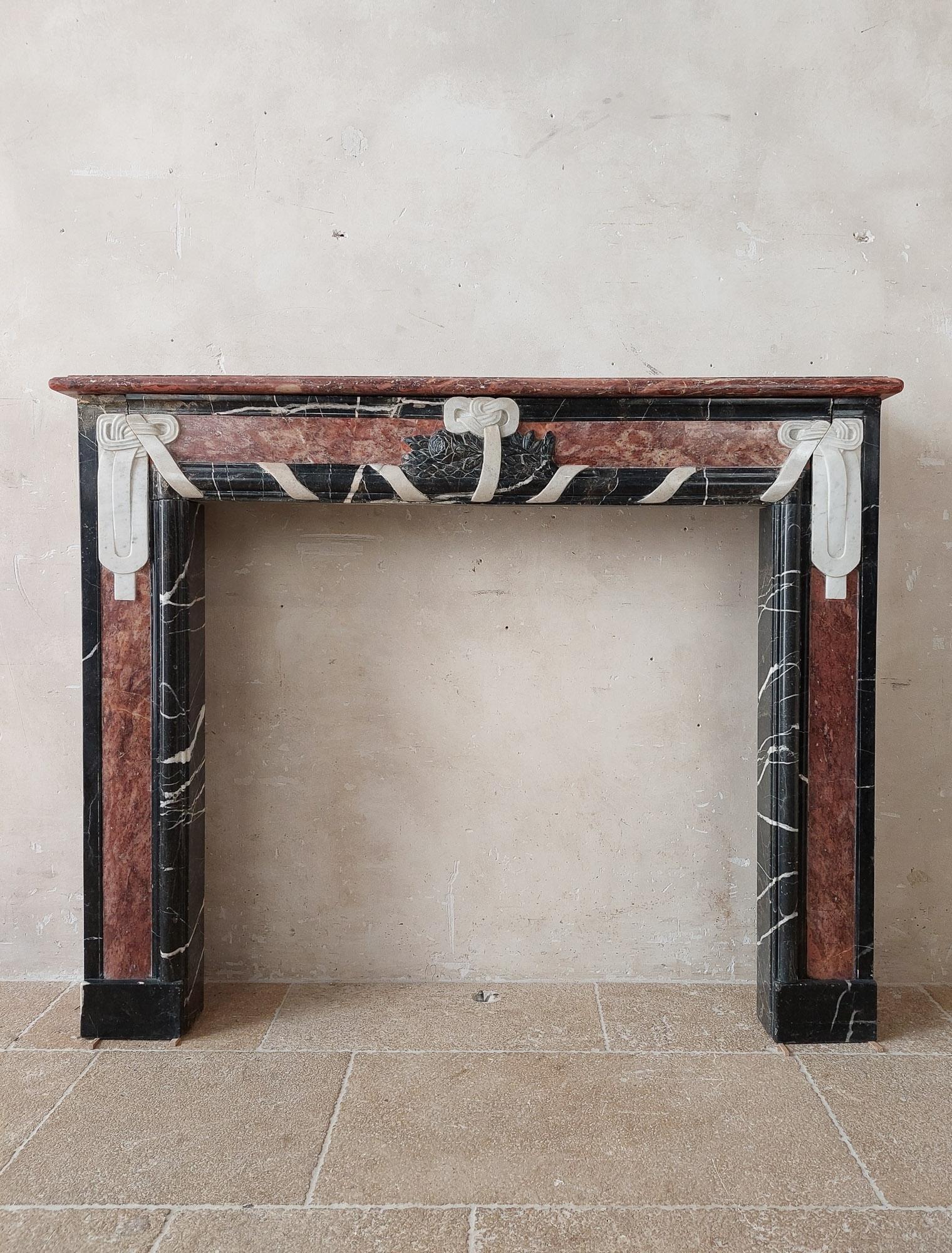 Special three-color marble Art Deco fireplace. From the transistion period, in the early 20th century, with influence of both Art Nouveau and Art Deco, with A-symmetrical floral decoration in the center and ribbon-shaped decorations in clean lines.