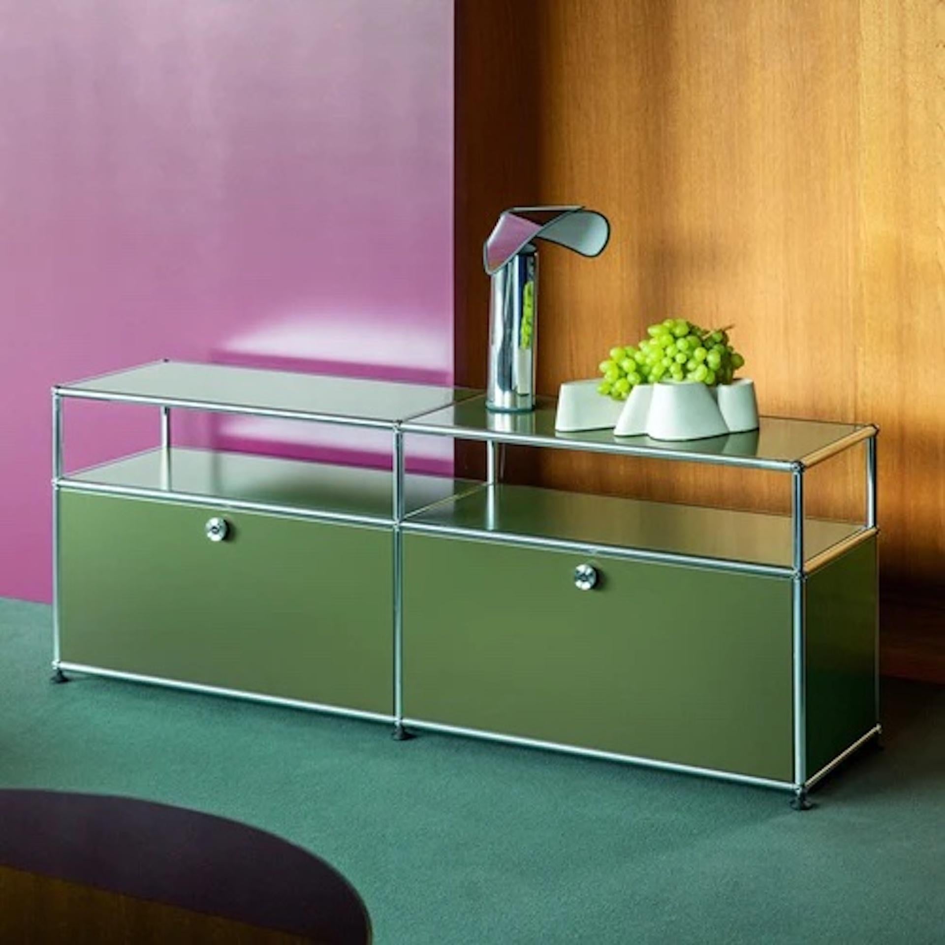 Special Edition Olive Green
Media storage credenza with two drop down doors that lock with the twist of a coin. Cable cut out is included.
The USM Haller system is made of powder-coated steel panels and chromed steel frame. GREENGUARD and Cradle to