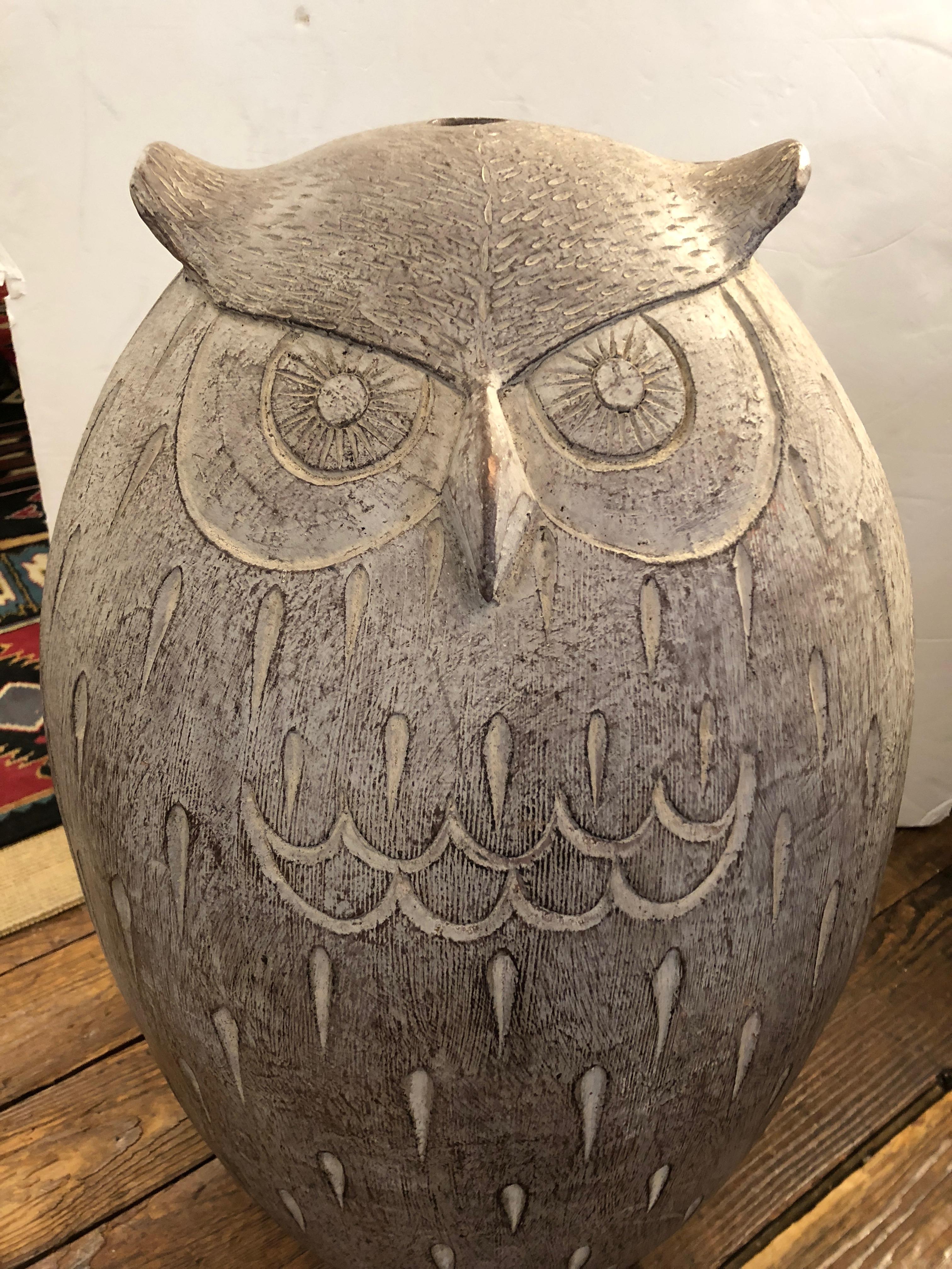 Fetching large terracotta owl sculpture that can be used indoors or in the garden, having an abstract style and faces on both sides. Color is greyish white, very neutral.