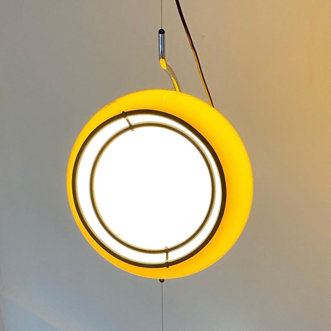Stunning and awesome are probably the first words which describes this floating light produced by Harvey Guzzini in the early 1970s. 

The iconic Art 4513 with the sideway tilted huge yellow shade floating on an almost invisible metal cable. To