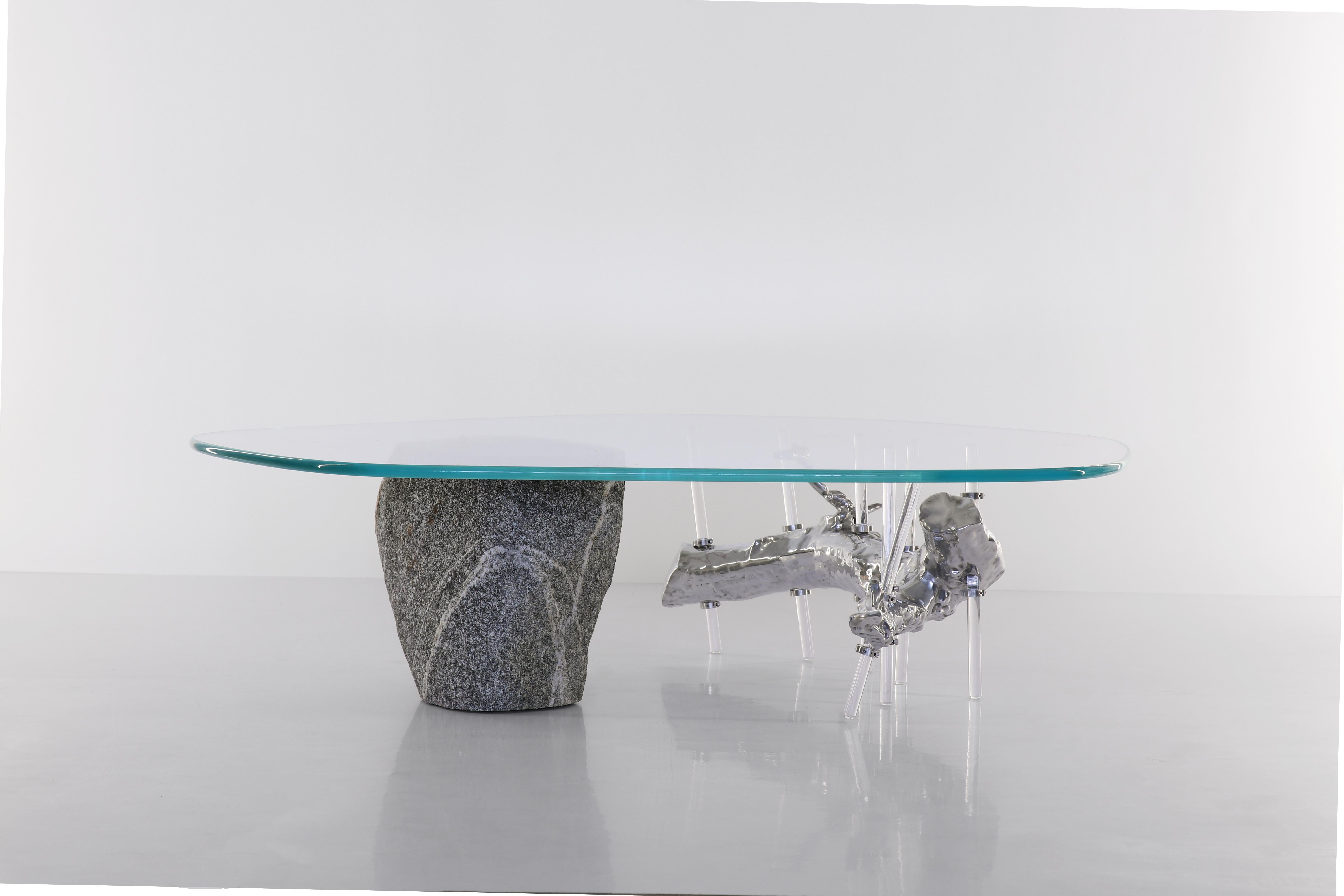 Specimen coffee table by Batten and Kamp
Dimensions: D110 x H30 cm
Materials: Cast aluminium, granite stone, tempered low iron glass.

The coffee table ‘Specimen’ features an aluminium casting of a gnarled branch and a cut and polished granite
