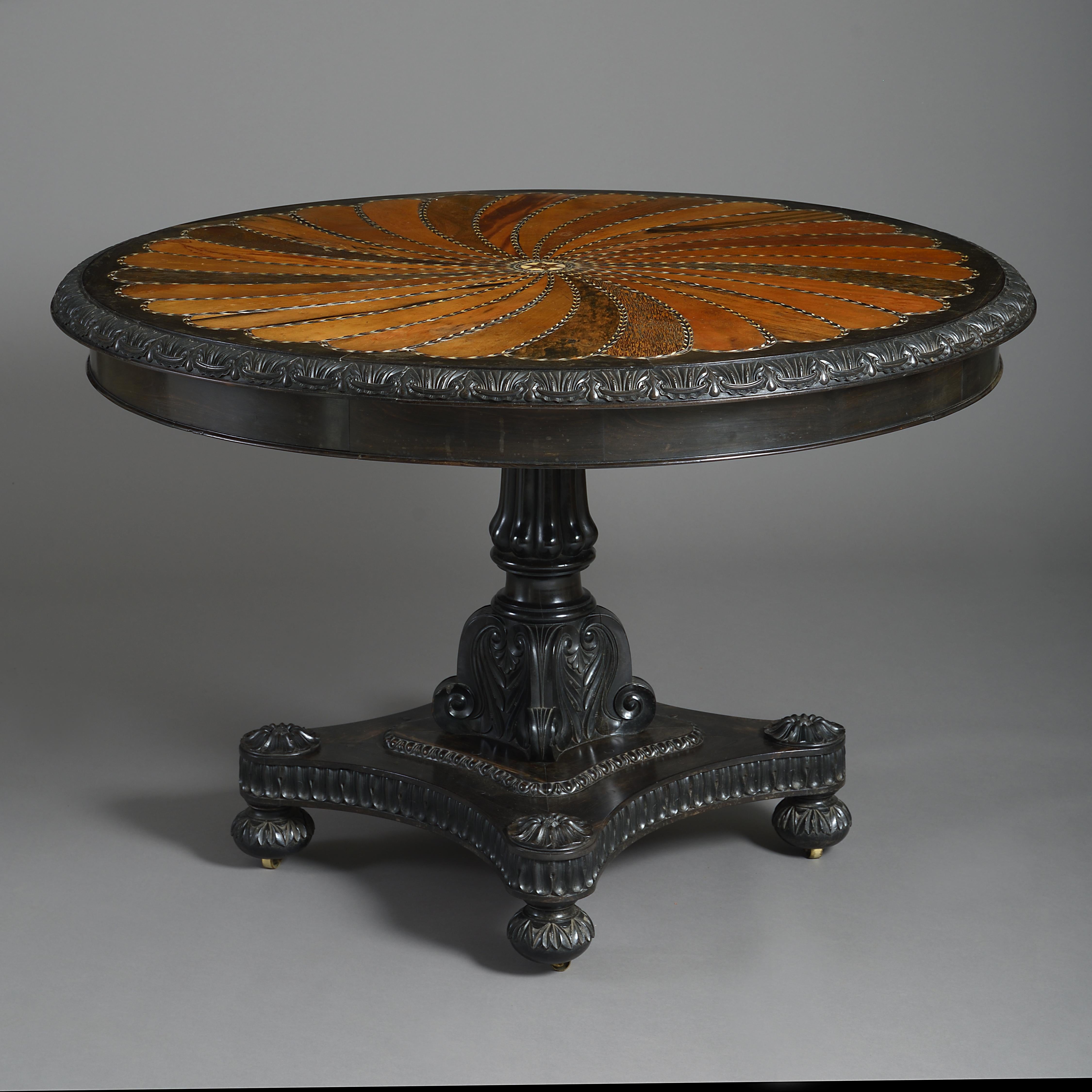 A fine Anglo-Indian ebony and specimen wood centre table, Ceylon, circa 1850.

The circular top with panels of palm wood, satinwood, Macassar ebony, calamander, and other woods within ivory and ebony fillets.