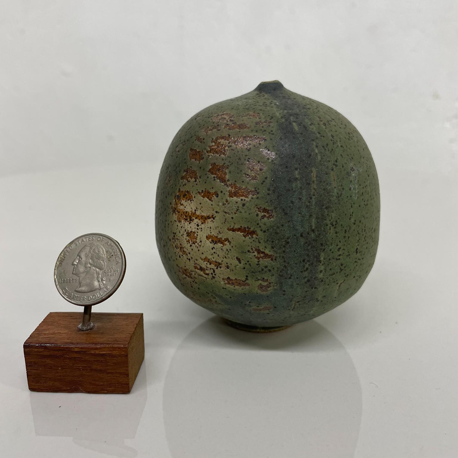 Vessel vase
Mini Weed Pot Bud Vase Stoneware Pottery Fire Glazed tones.
Speckled Texture Green Bronze tones Mini Weed Pot Style of Rose Cabat Feelie Vase 1970s California
Stamped on bottom. Unable to read signature.
3.25 diameter x 3.5 tall
Original