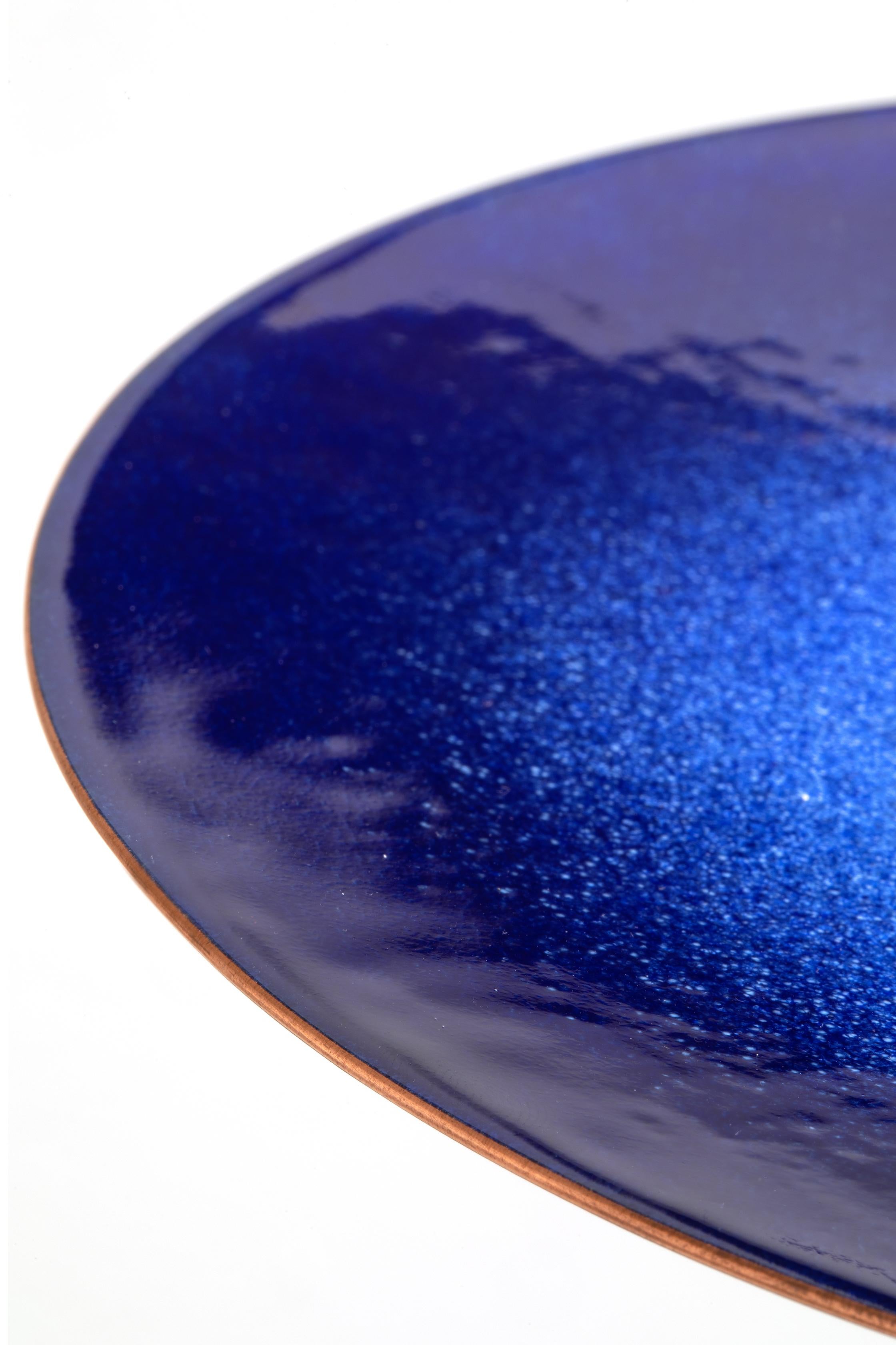 Decorative plates made of enameled copper, a complex decorative technique that involves subjecting a copper object covered with glass powders to firing at a very high temperature, a process that ensures surprising coloration and brilliance. The