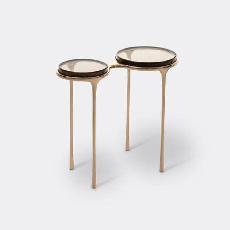 Inspired by a pair of vintage eyeglasses, the Spectacles Side Table is a unique design vision brought to life. The base is made of cast-bronze with thin tapered legs, while the dual surfaces are inset with cast-glass tops. Whether alongside a sofa