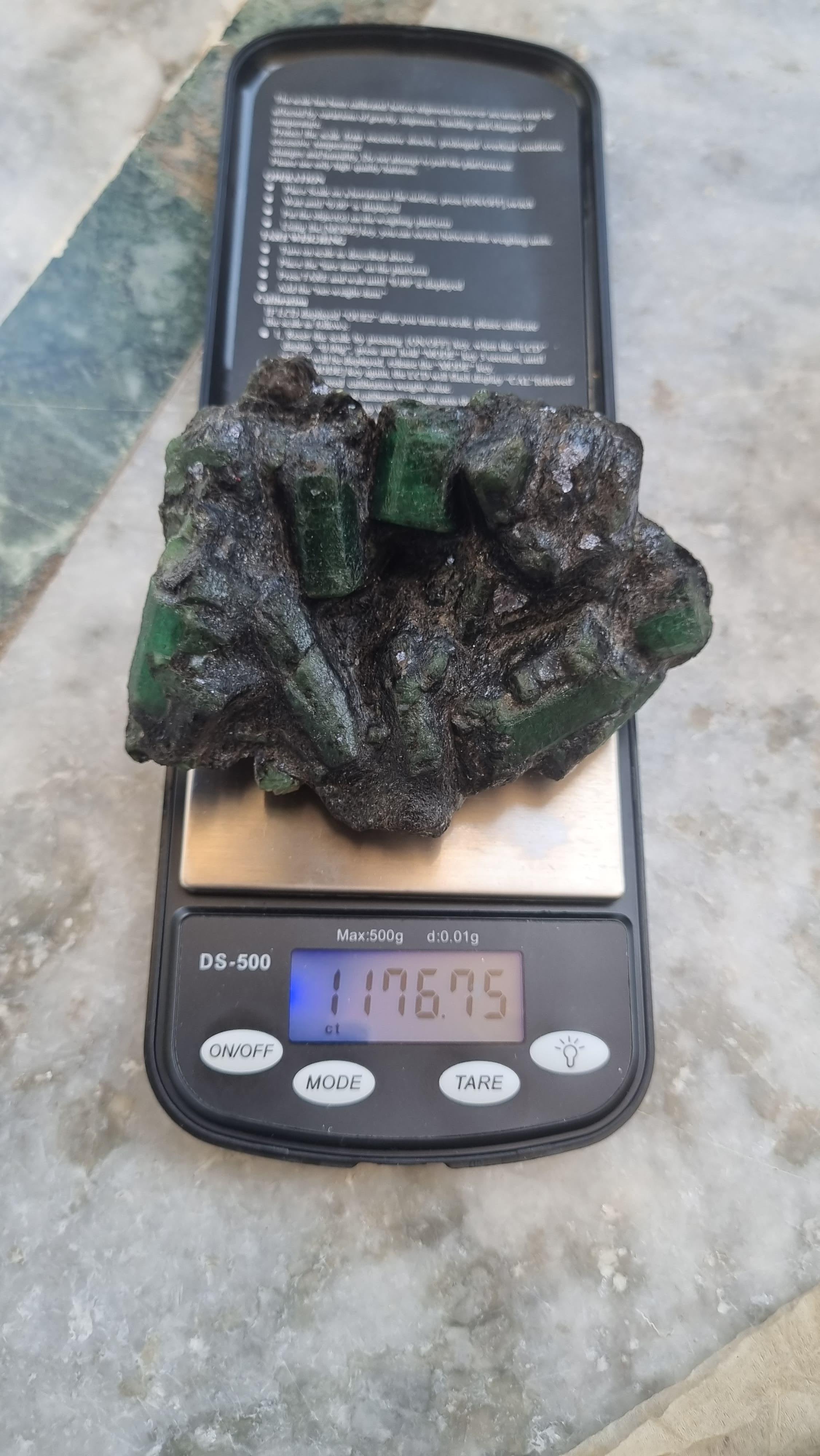 Wir präsentieren einen spektakulären brasilianischen Rohsmaragd von 1167 Karat, einen außerordentlich seltenen Edelstein, der sich durch seine beeindruckende Größe, seine auffallende natürliche Schönheit und seine einzigartige geologische