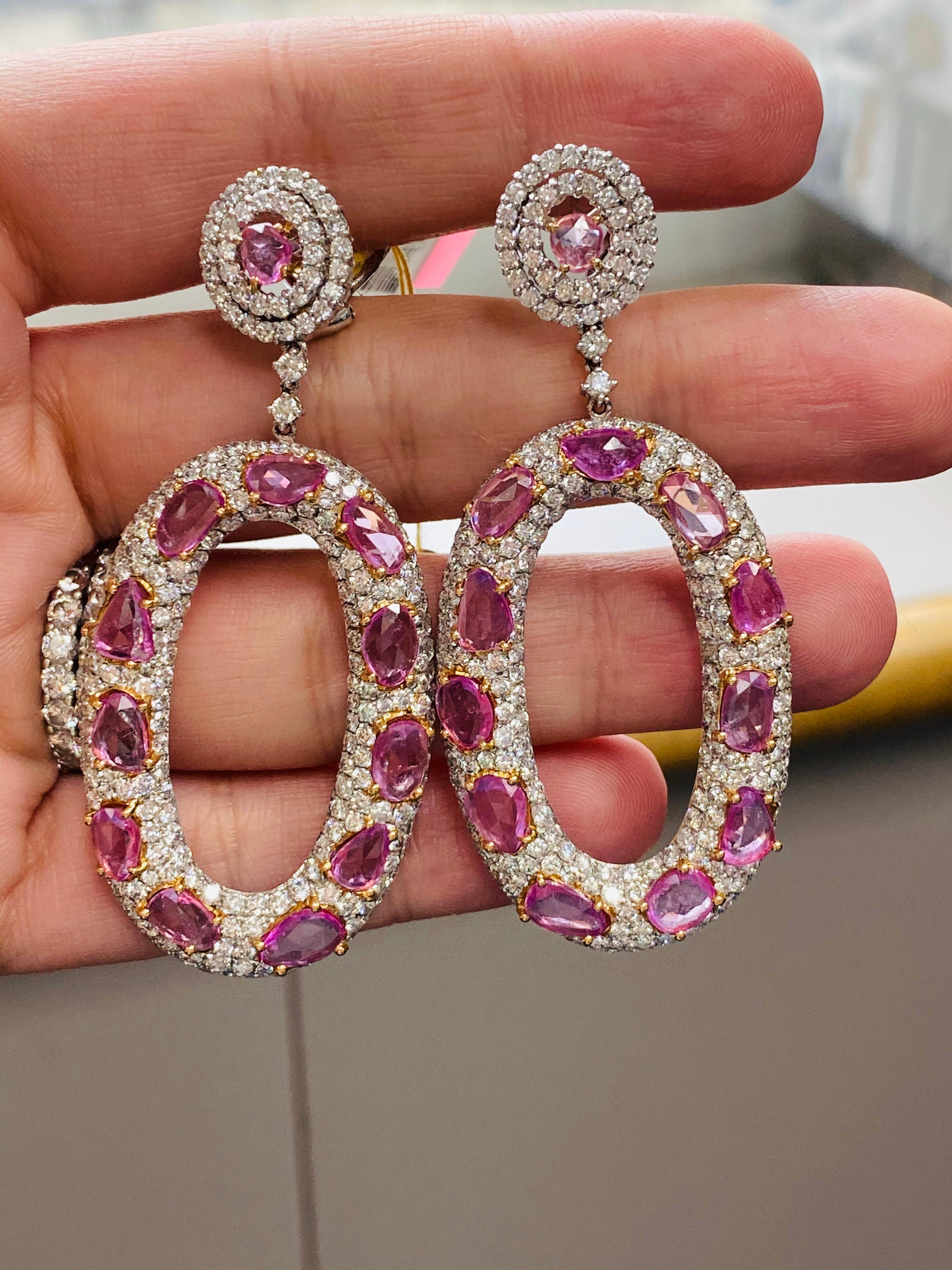 18K White gold pink sapphire and diamond oval shaped earrings, features 12.62 carats of natural pink sapphires surrounded by 10.85 carats of diamonds. 
