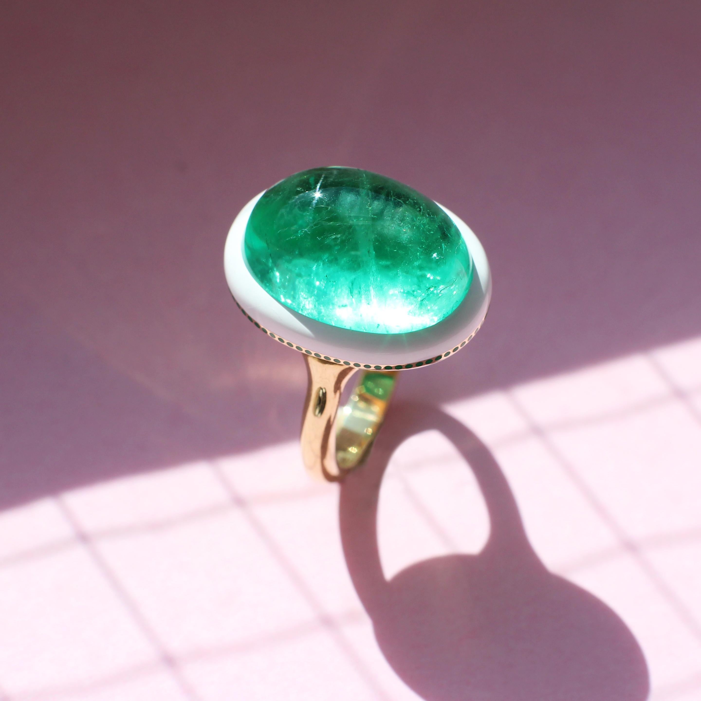 A ring for someone who likes things done differently, this yellow gold ring suits every occasion. Its spectacular cabochon emerald was rescued from an outdated ring and now forms a smooth, oval centrepiece atop a white ceramic surround. Tiny green
