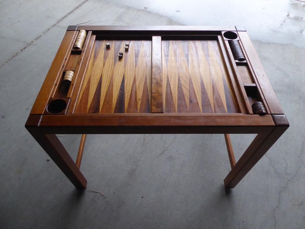 A spectacular backgammon table, handmade by a woodworking artisan in the 1970s. The table is joined using dowels and is made from solid walnut, incorporating oak and rosewood triangles (points) on the playing surface. The bar that runs down the