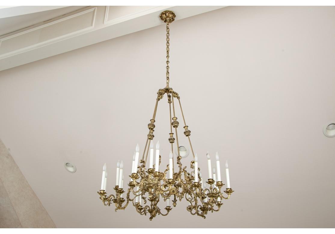 Regal and fine French Gilt Bronze Chandelier with an intricate open design. Each arm has the appearance of a five light chandelier and the five hanging rods are defined by cartouche type elements at the half mark. A ceiling cap with Scroll Work is
