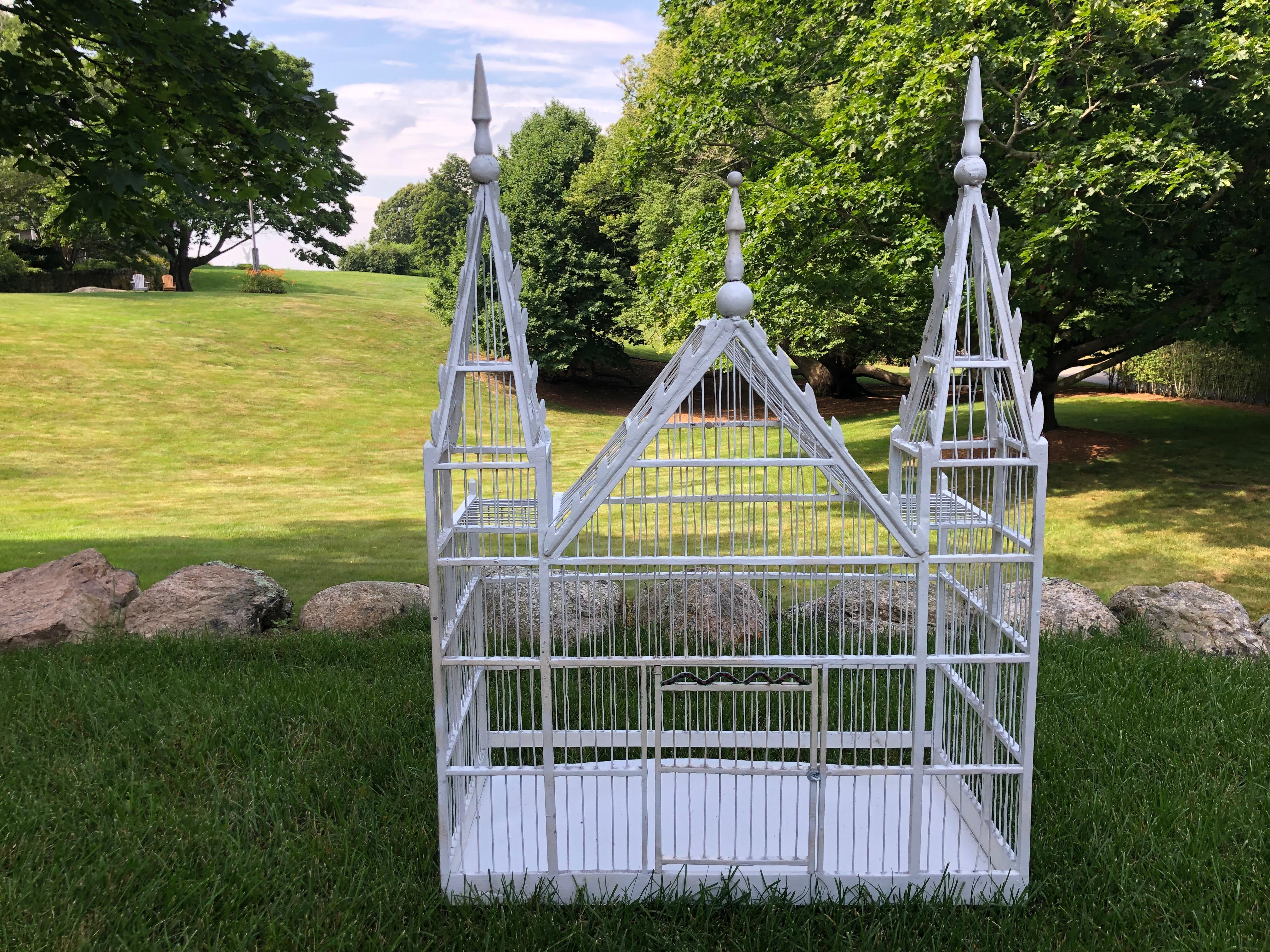 Spectacular antique French birdcage with great proportions and detail. There is a sliding tray and door that opens with decorative painting over top. The birdcage is in excellent condition for its age. If using for a pet bird, a paint sealant is