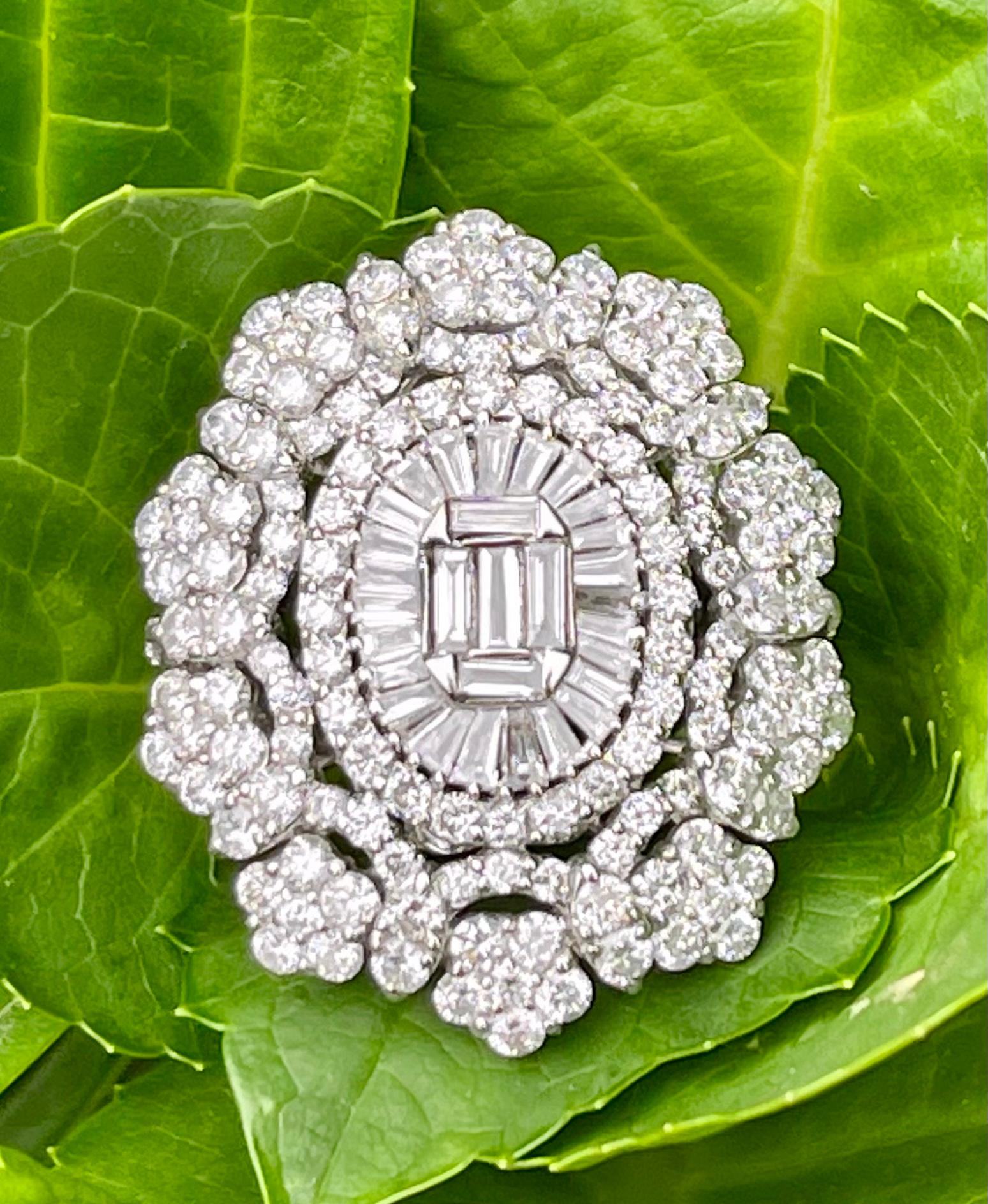 A spectacular, very sparkly in real life, approximately 9 carat diamond oval medallion shaped cocktail ring is set in 18 karat white gold and is comprised of approximately 203 round brilliant and baguette cut diamonds.  The medallion design features