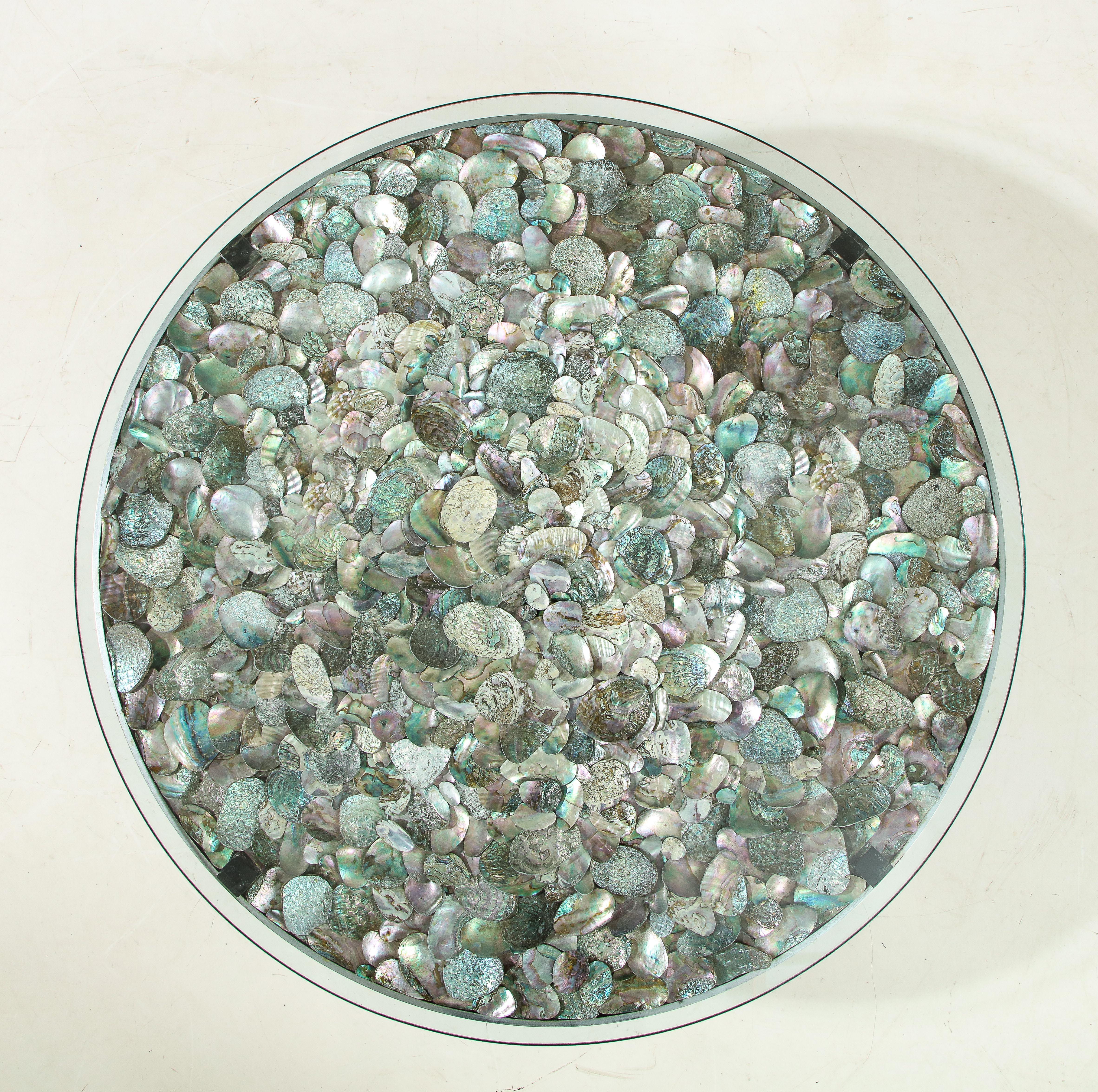The Minimalist round base beautifully features the 100's of Abalone shells used to create this stunning coffee table. 
The glass top sits up on four Lucite cubes, which reflects the iridescent shells.
  