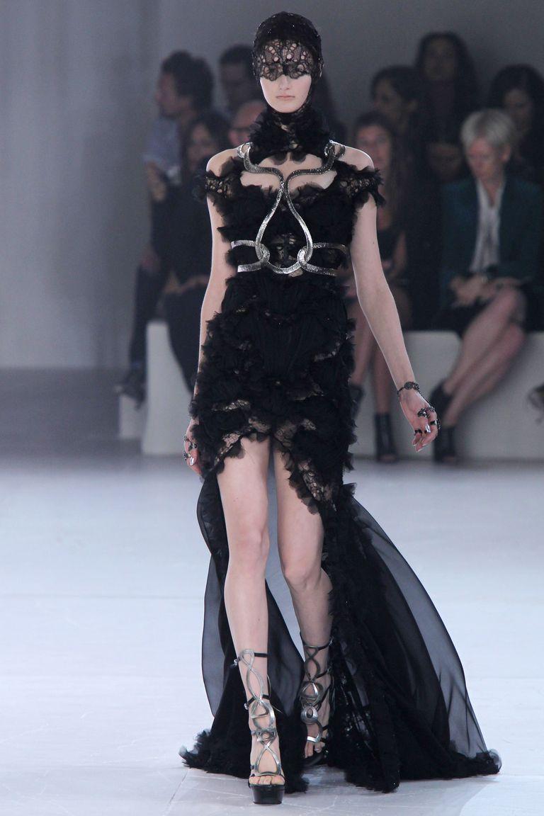 As if conjured from midnight sea-spray, this Spring/Summer 2012 Alexander McQueen gown unfurls like a dark bloom caught in motion. The bodice - sculpted close to the torso -disappears beneath hundreds of hand-cut silk-organza petals, each