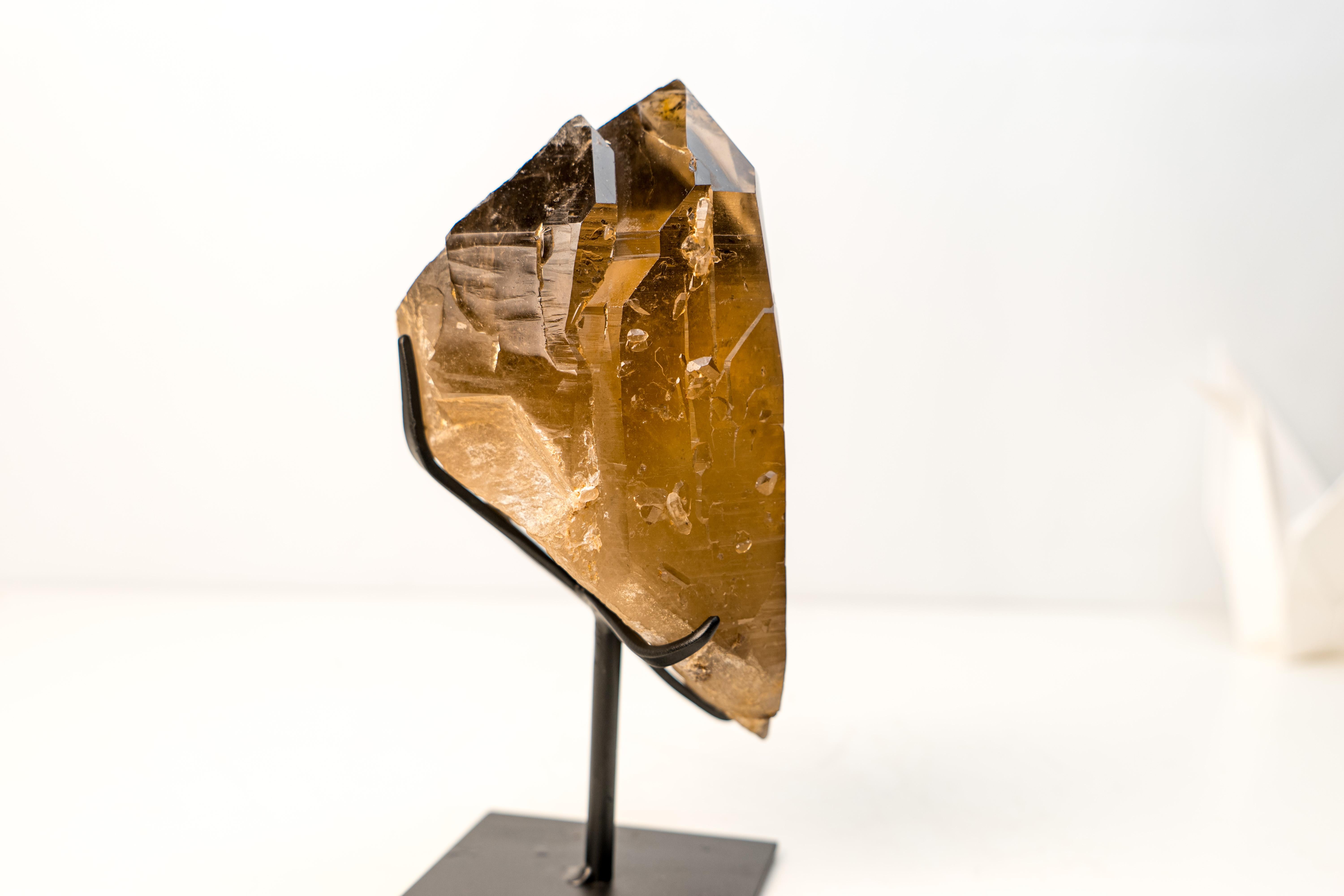 Elestial Golden-Amber Citrine 

▫️ Description

Bringing a gorgeous color tone and remarkable aesthetics, this high-grade citrine crystal specimen displays a golden-amber hue that gradually transitions from smoky bronze at the base to a honey-gold