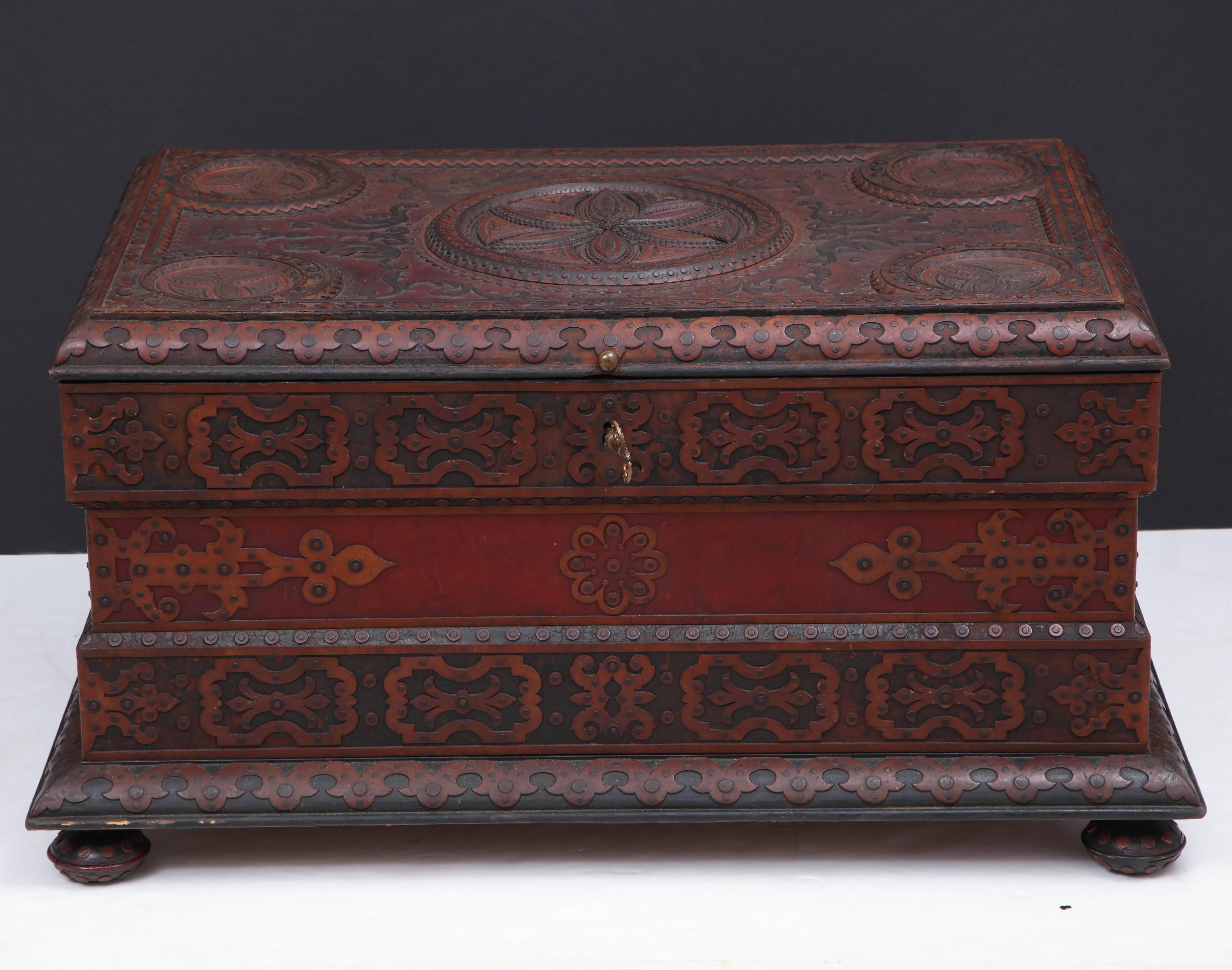A spectacular and large tramp art blanket box, circa 1890-1910, constructed with layered leather, embossed and carved contrasting leather and wood. This box was found in Sweden but could possibly be of North German decent. It is unusual to find this