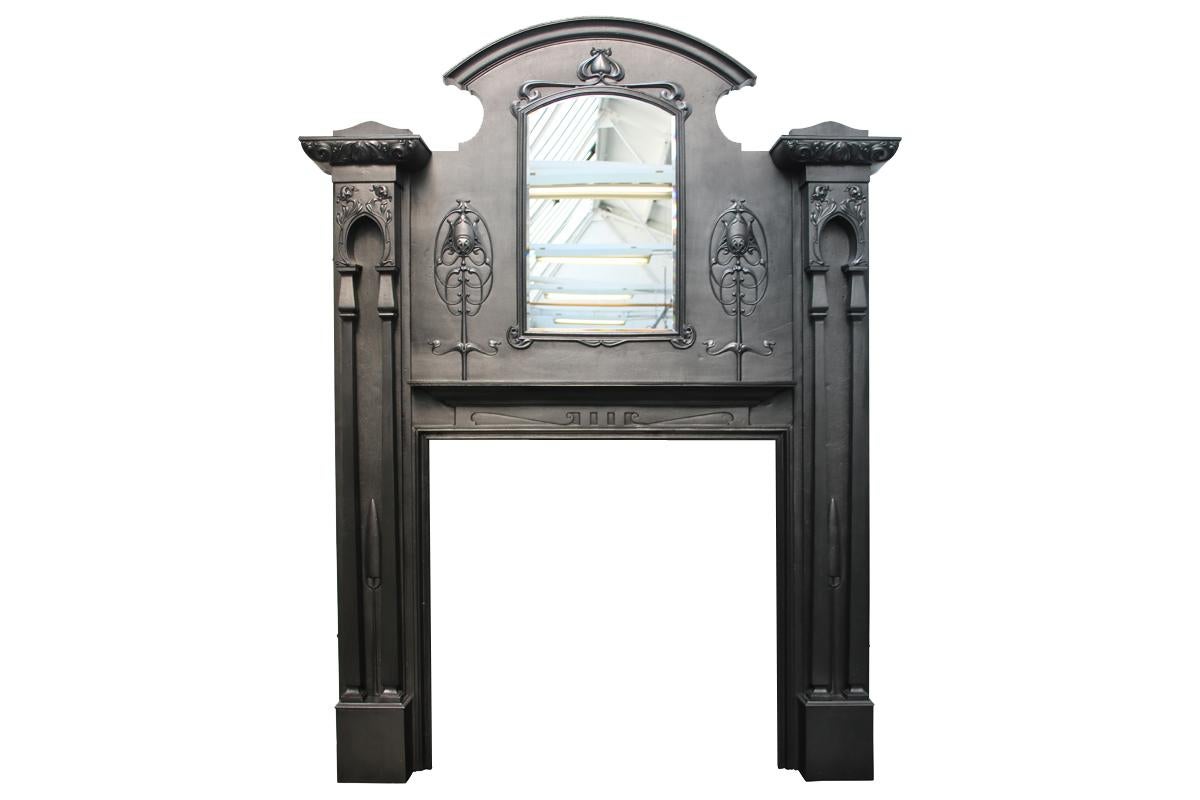 Spectacular and rare tall Art Nouveau Edwardian cast iron fireplace surround with full height twin square pillars supporting ornate capitals, surmounting a large frieze with beveled mirror plate framed with a delicately cast iron frame above a cast