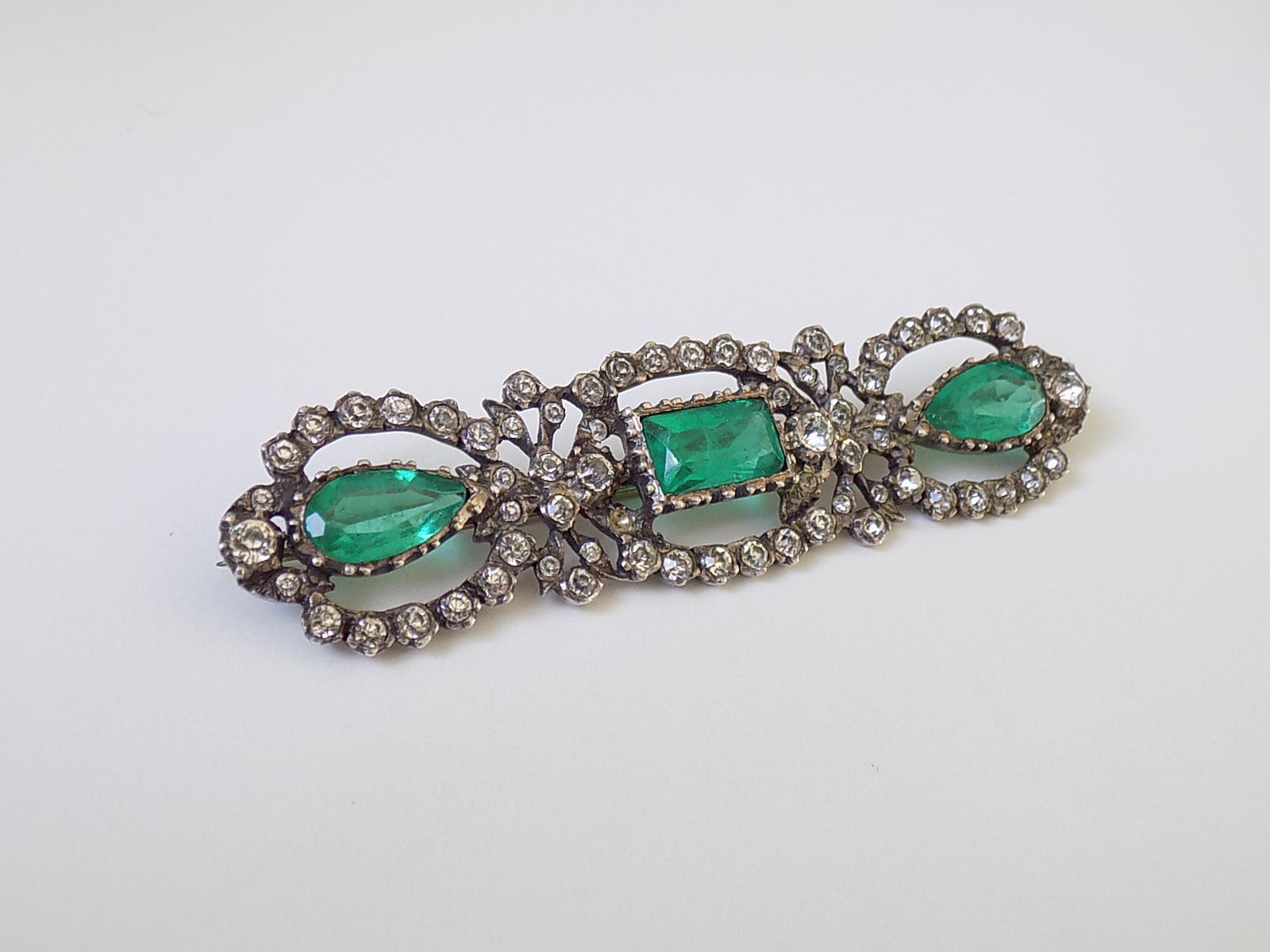 This is a spectacular Edwardian period Emerald paste & Diamond Lazarus paste (glass) brooch in solid Sterling silver mount. The brooch made in Georgian style. British origin. 
Lazarus paste was founded by British maker Harold A. Lazarus in 1900. Who