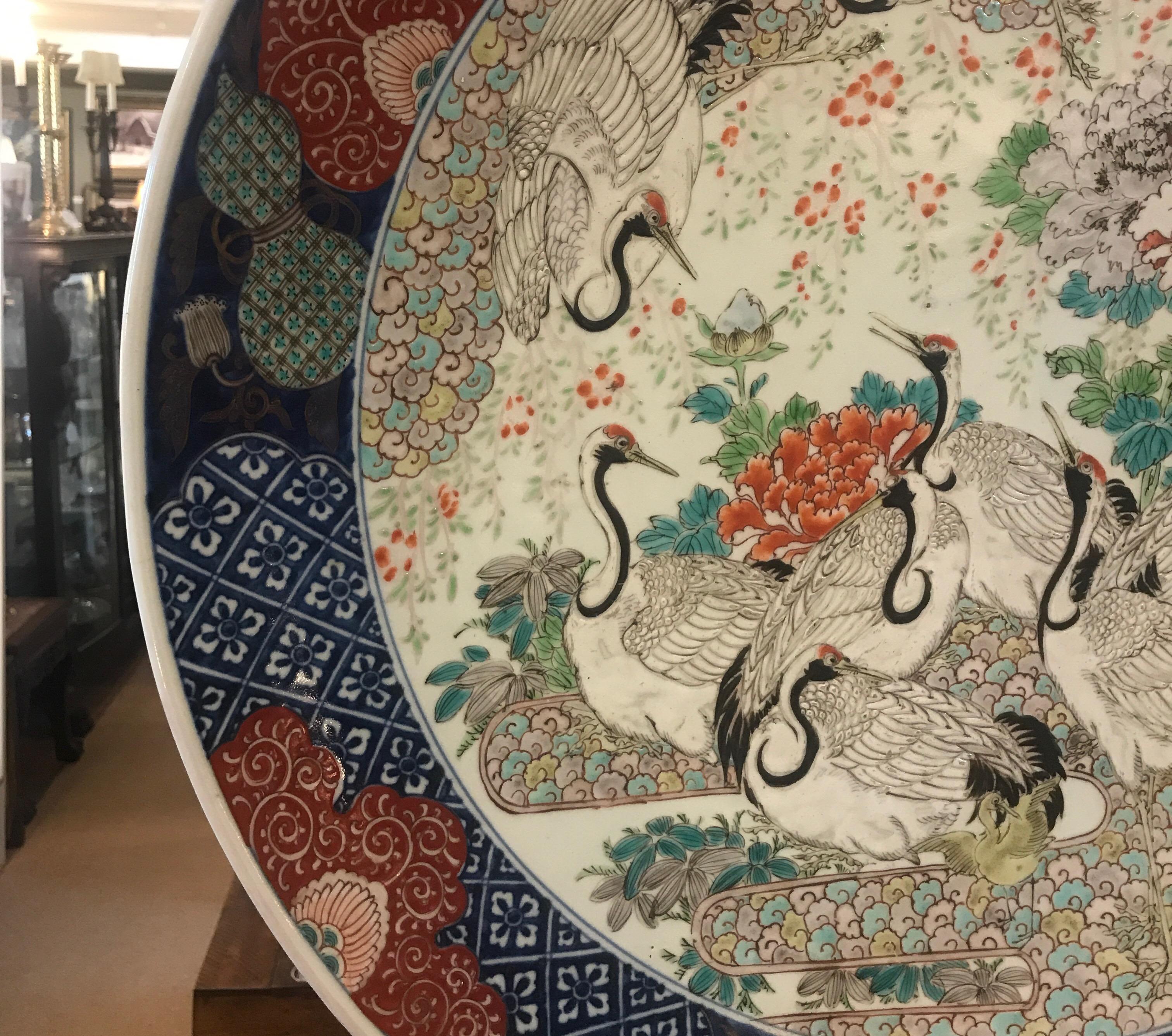A profusely hand decorated Japanese Imari porcelain charger with cranes and gords in classic iron red, cobalt blue. Exceptional skilled hand painting, highest quality in the manner of Fukagawa.