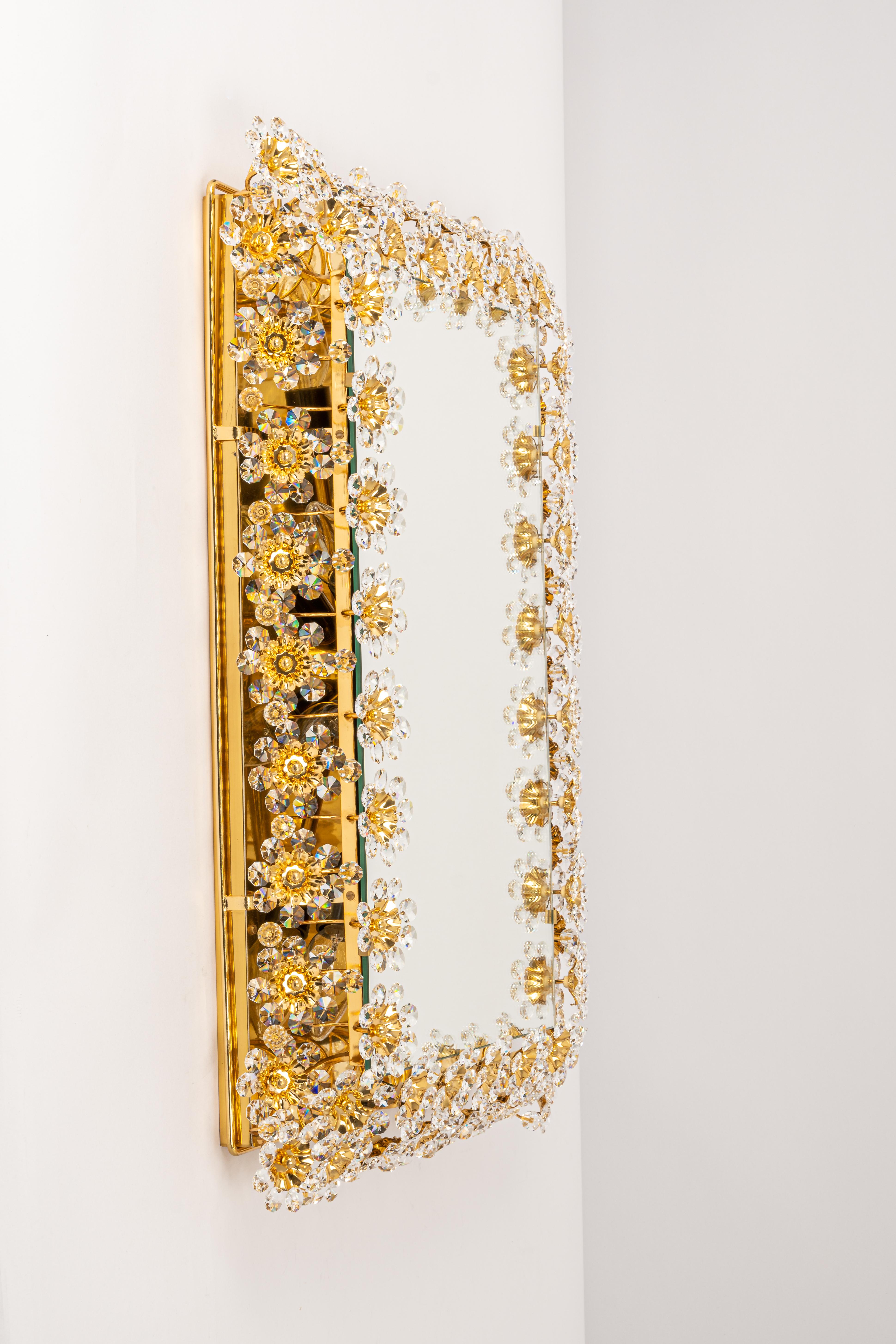 Ein wunderschöner und hochwertiger vergoldeter Wandspiegel von Palwa (Palme & Walter), Deutschland, 1970er Jahre
Sie besteht aus einem Rahmen aus 24 Karat vergoldetem Messing, der mit Hunderten von geschliffenem Kristallglas verziert ist.