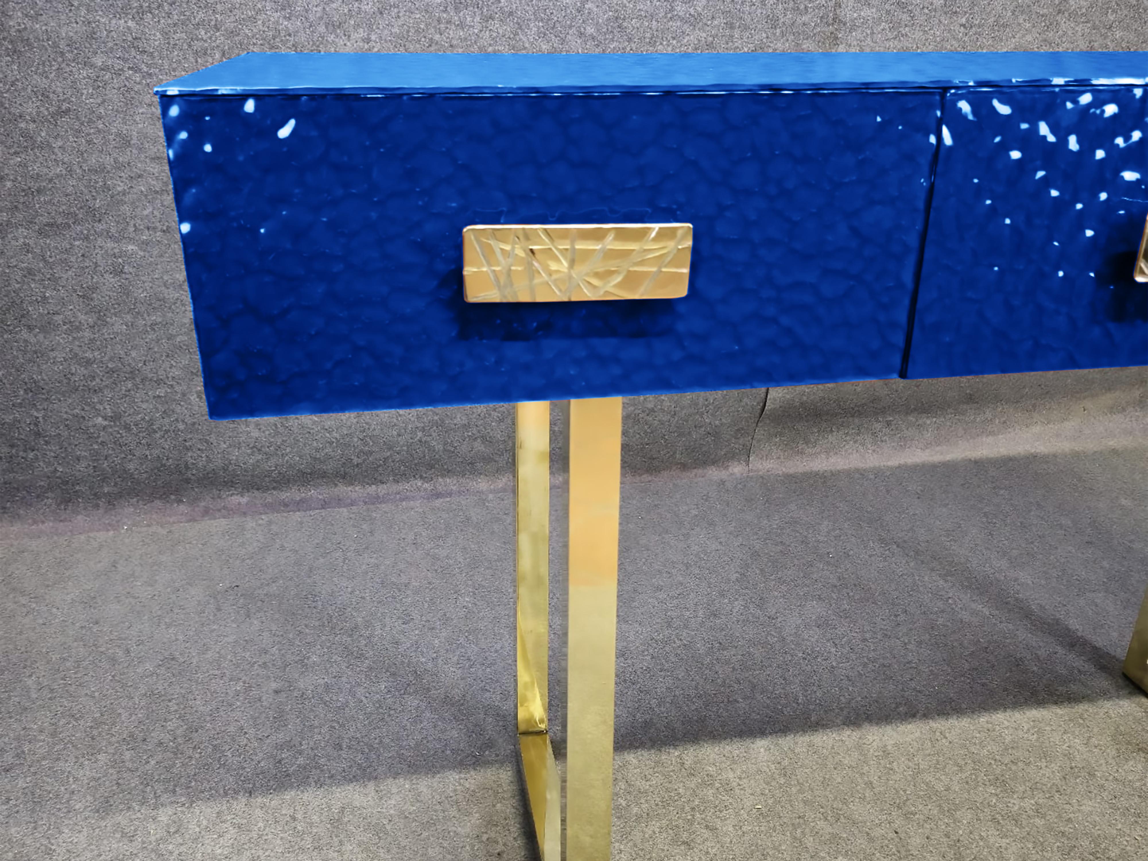 Espectacular consola de cristal de Murano azul con tres amplios cajones, fabricada con maestría en Italia. 

Esta consola moderna de mediados de siglo está hecha de madera maciza de abedul, con una tapa de cristal de Murano azul biselado que